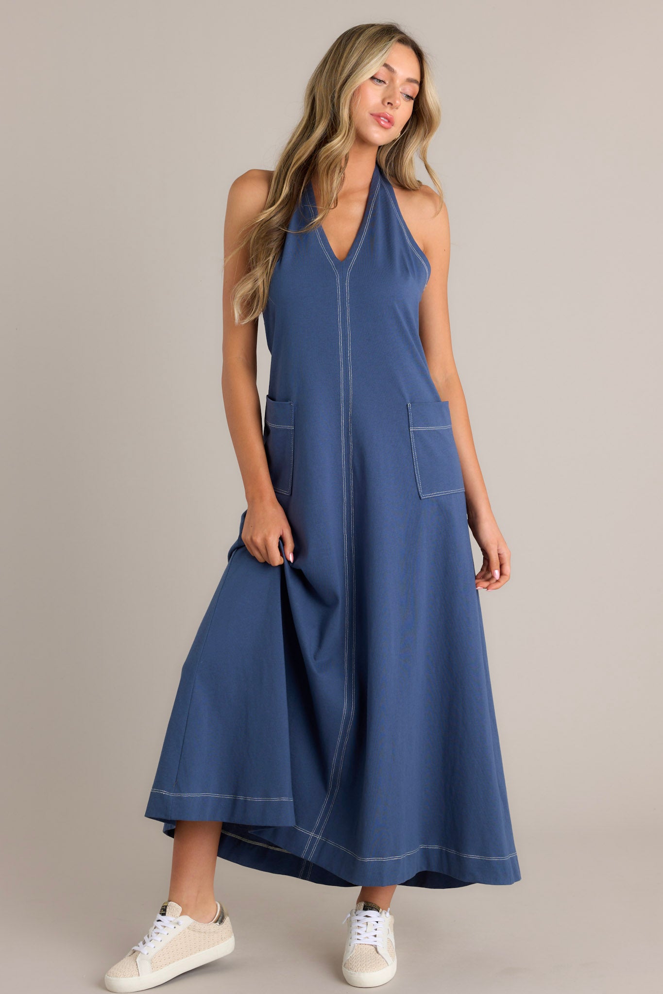 Angled front view of this relaxed-fit blue maxi dress with a plunging V-neckline and front patch pockets.