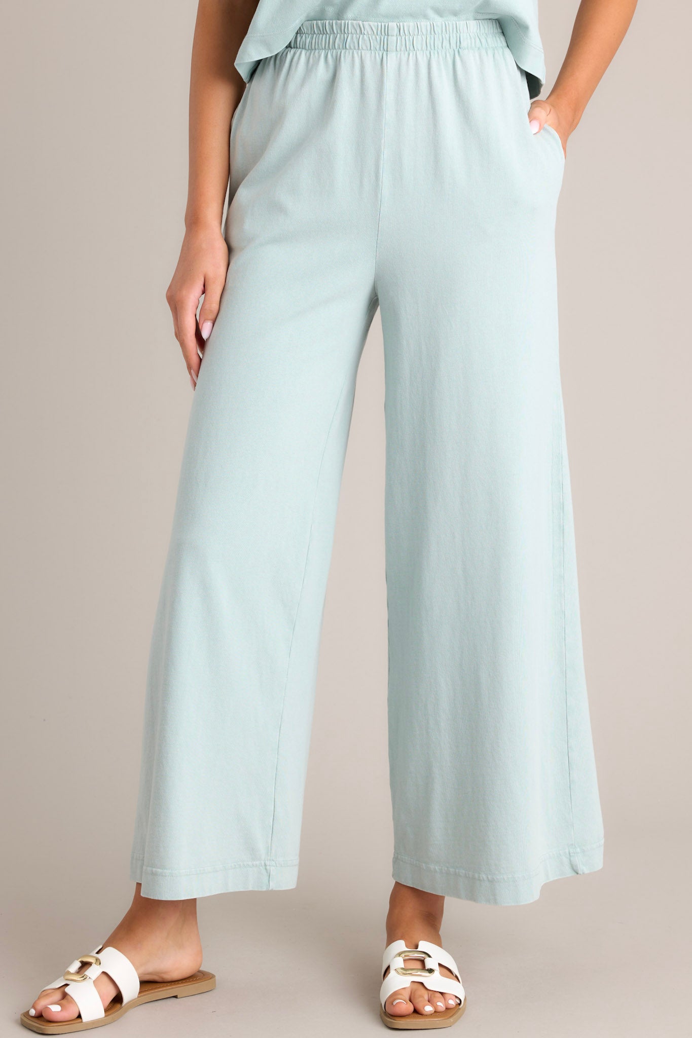 Front angled view of harbor gray flare pants featuring an elastic waistband, functional pockets, a wide leg design, and a soft jersey material