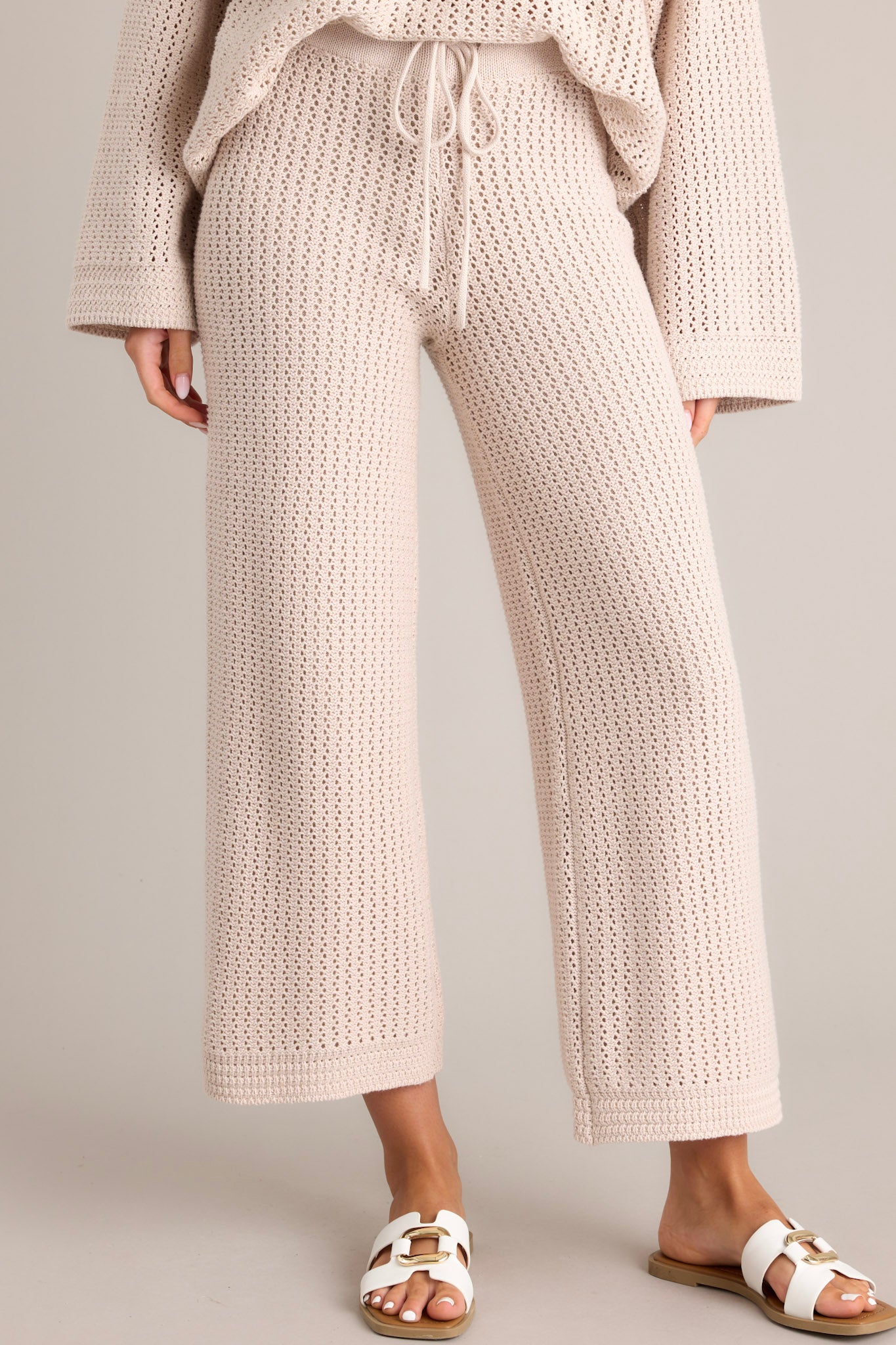 These natural crochet pants feature an elastic waistband, Drawstring detail, a cropped length, and a crochet material.