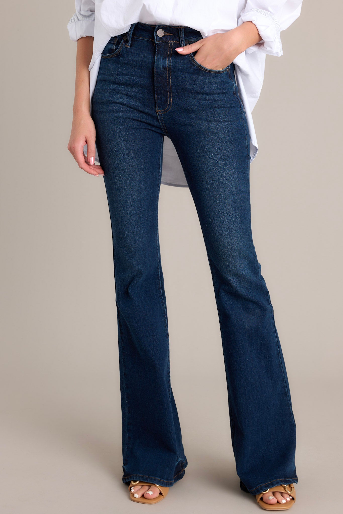 Front view of jeans featuring a classic button and zipper closure, belt loops, front and back pockets, a flared cut, and a dark wash.