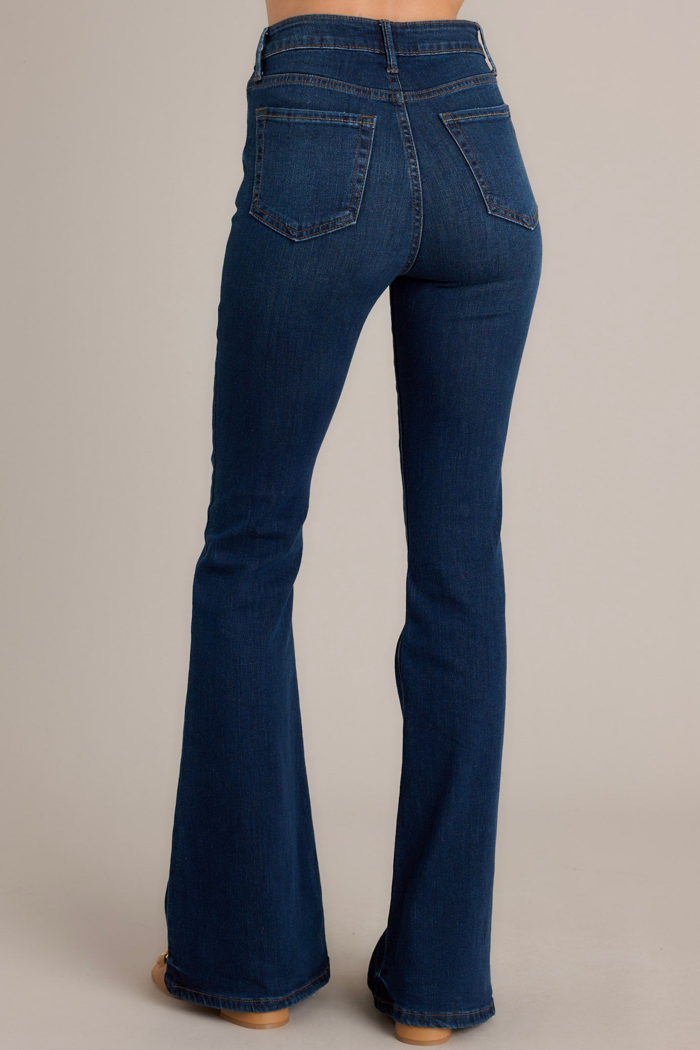 Back view of jeans highlighting the belt loops, back pockets, and flared cut.