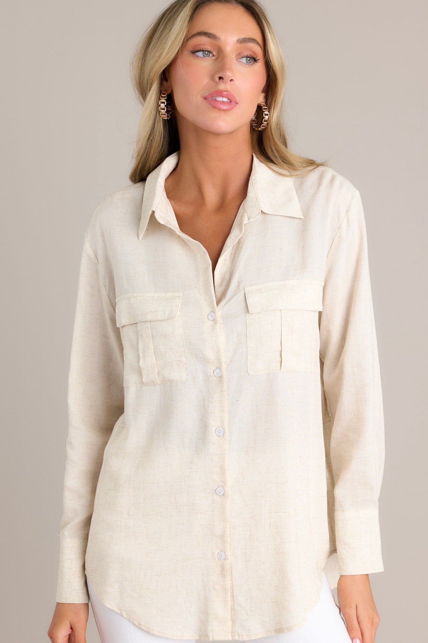 Front view of this top that features a collared v-neckline, a full button front, functional chest pockets, and buttoned cuffed long sleeves. 