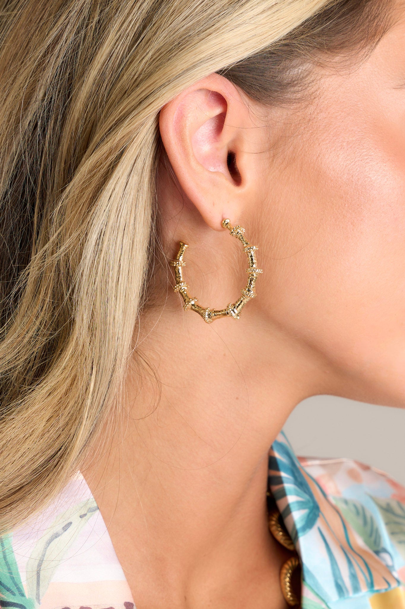 These gold earrings feature an incomplete hoop, a bamboo like design, and secure post backings.