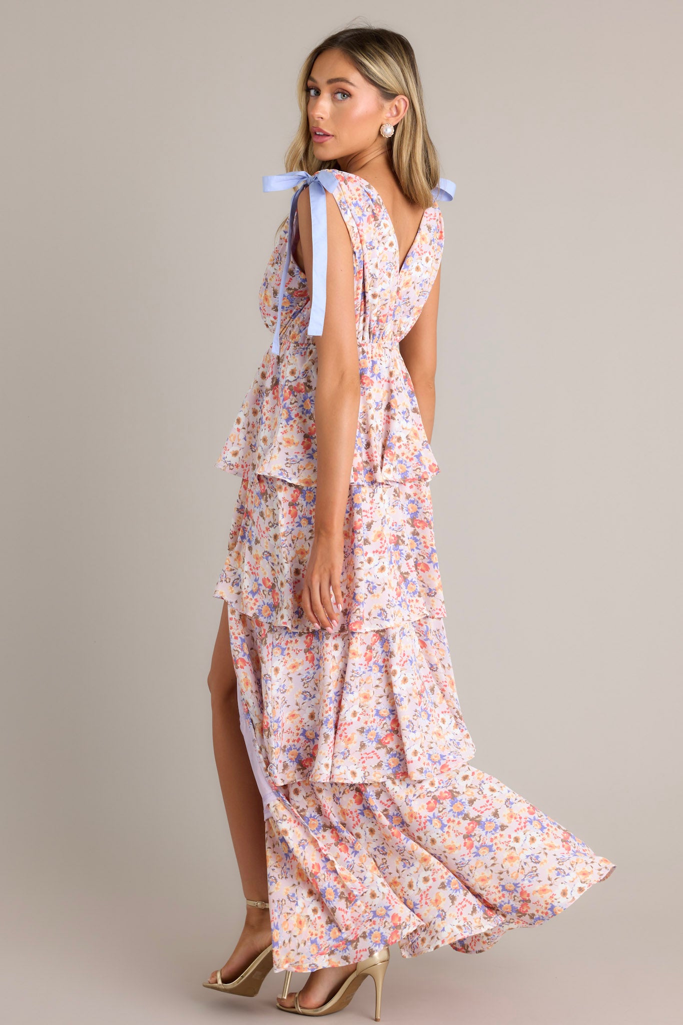 Side view of a lavender ruffled floral maxi dress with tied shoulder straps and a high slit, demonstrating the flow and movement of the layers.