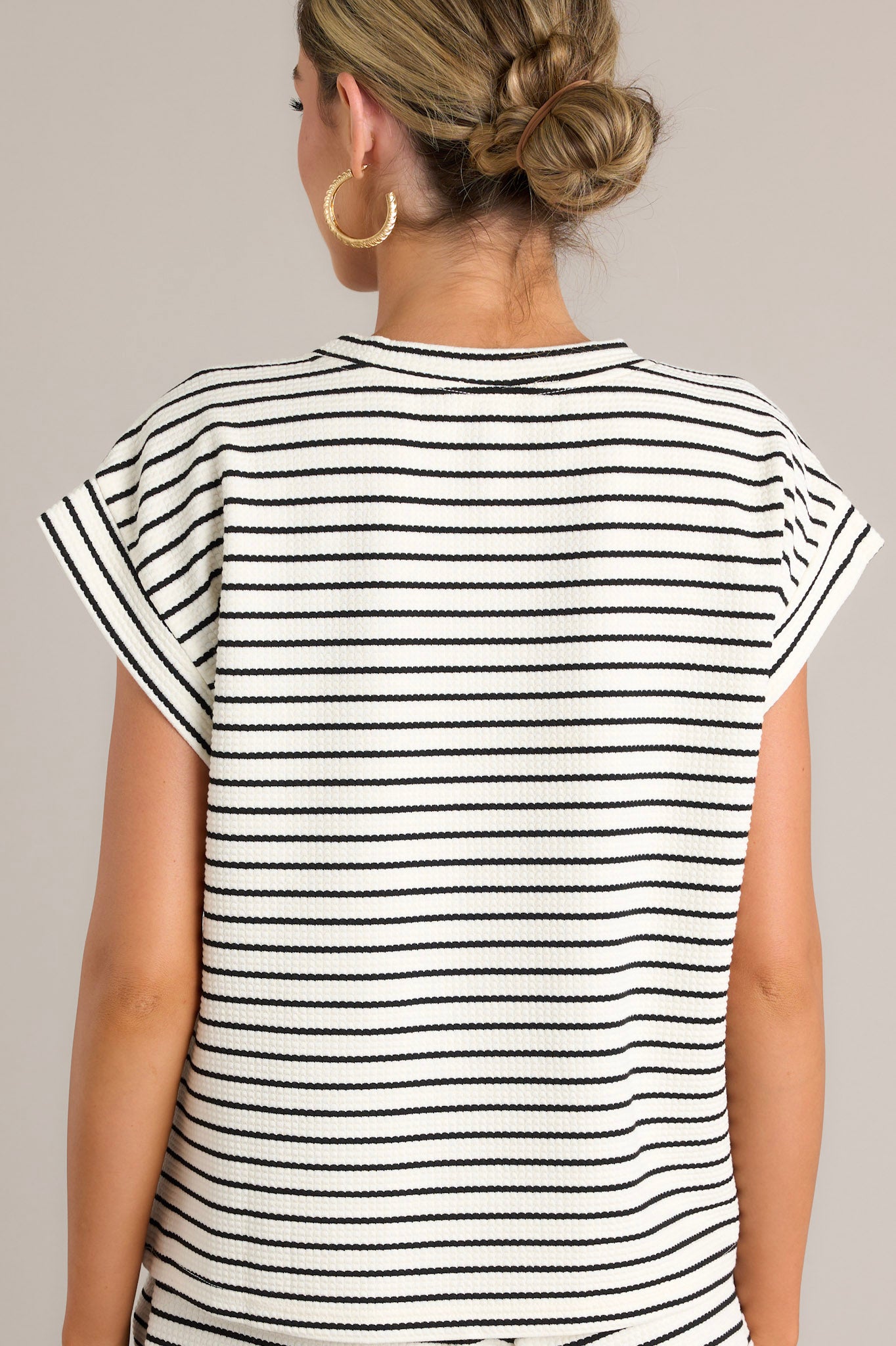 Back view of the striped top highlighting the horizontal stripe pattern and wide cuffed sleeves.