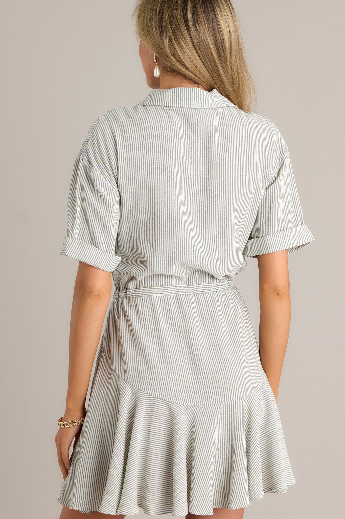 Back view of an olive stripe dress highlighting the collared neckline, self-tie drawstring waist, and overall fit.