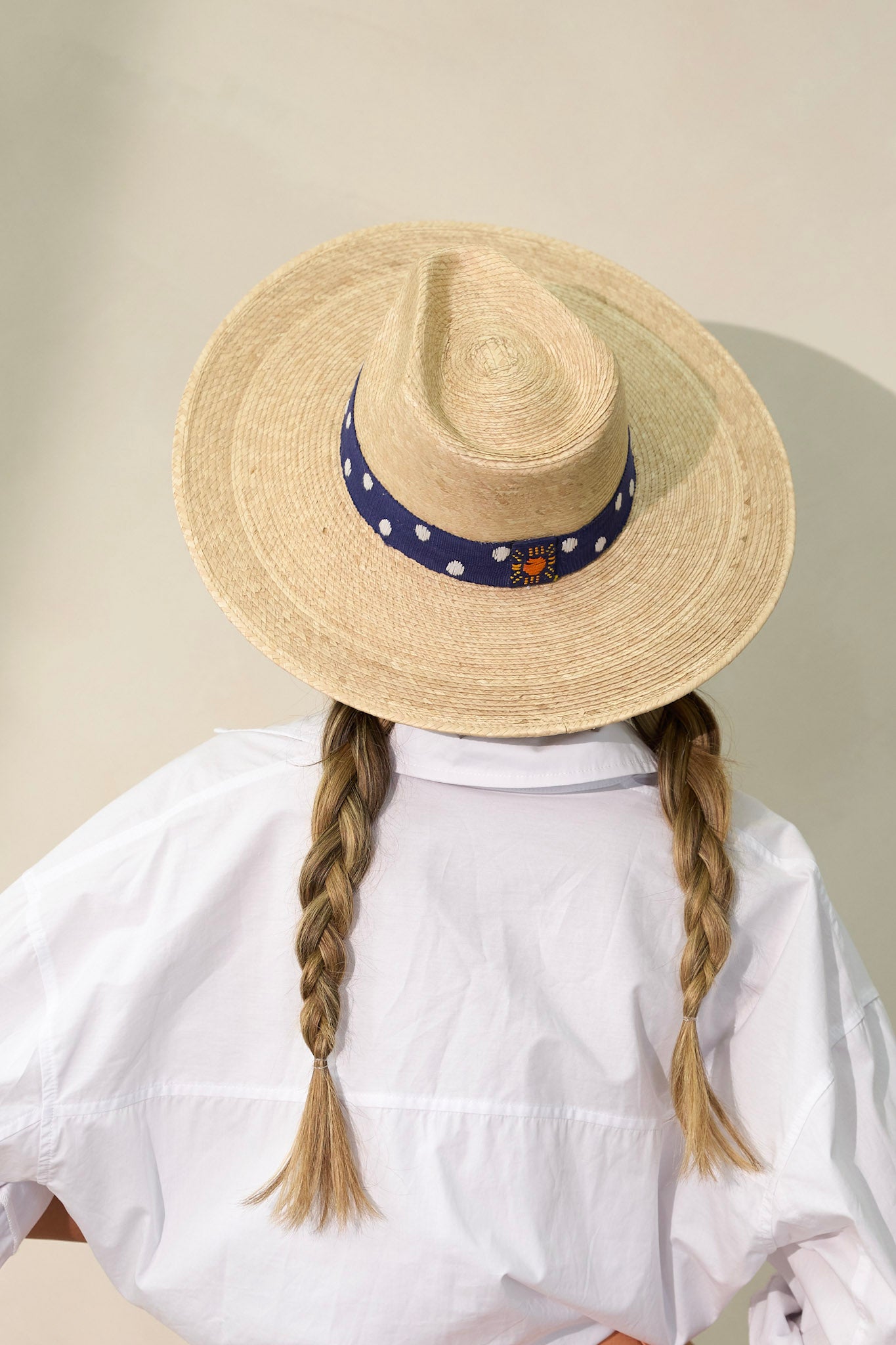 Back view of this Wendy hat features a navy, cotton woven band with white polka dots.