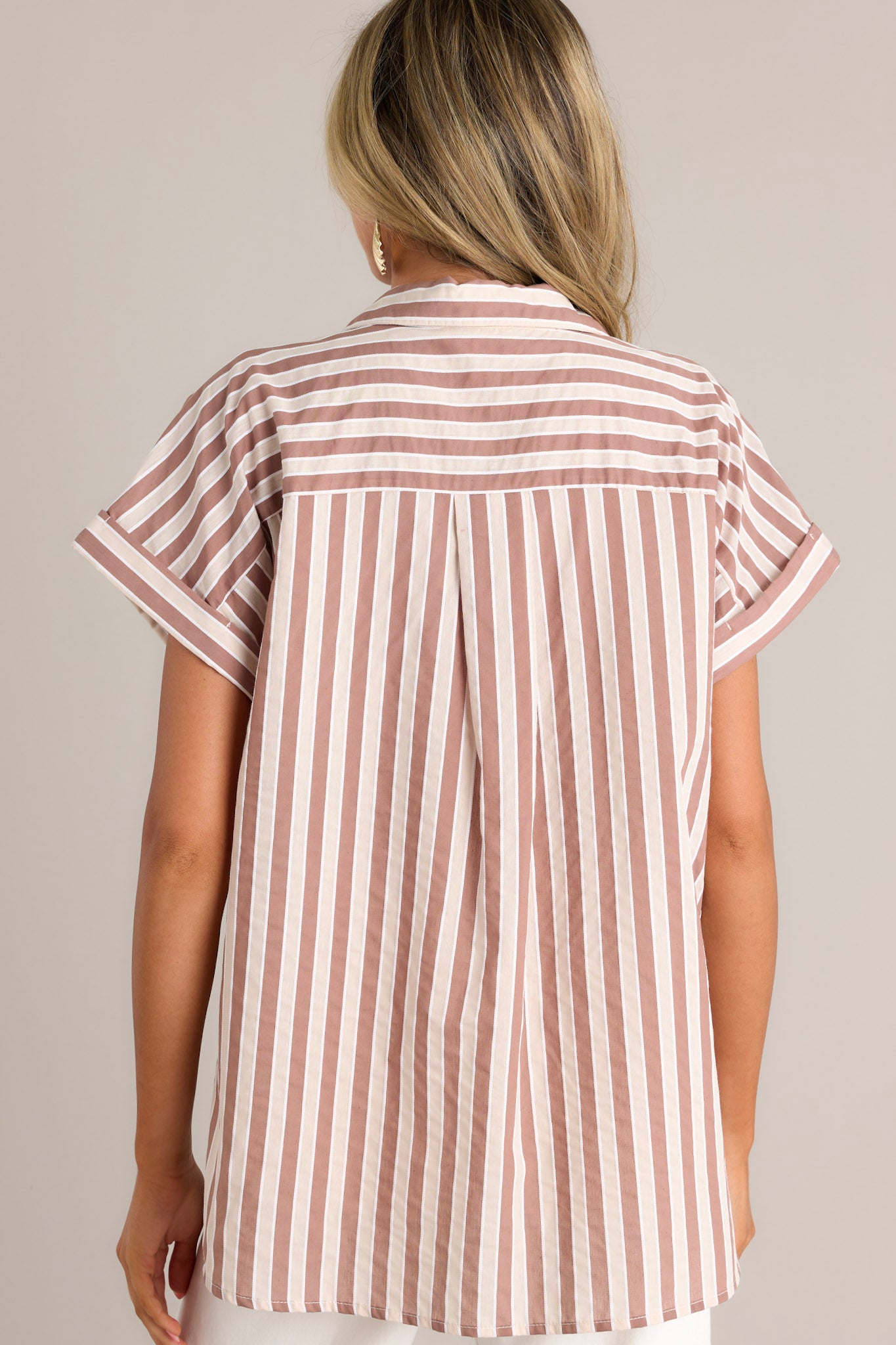 Back view of a tan stripe top highlighting the vertical stripe design, cuffed short sleeves, and overall fit.