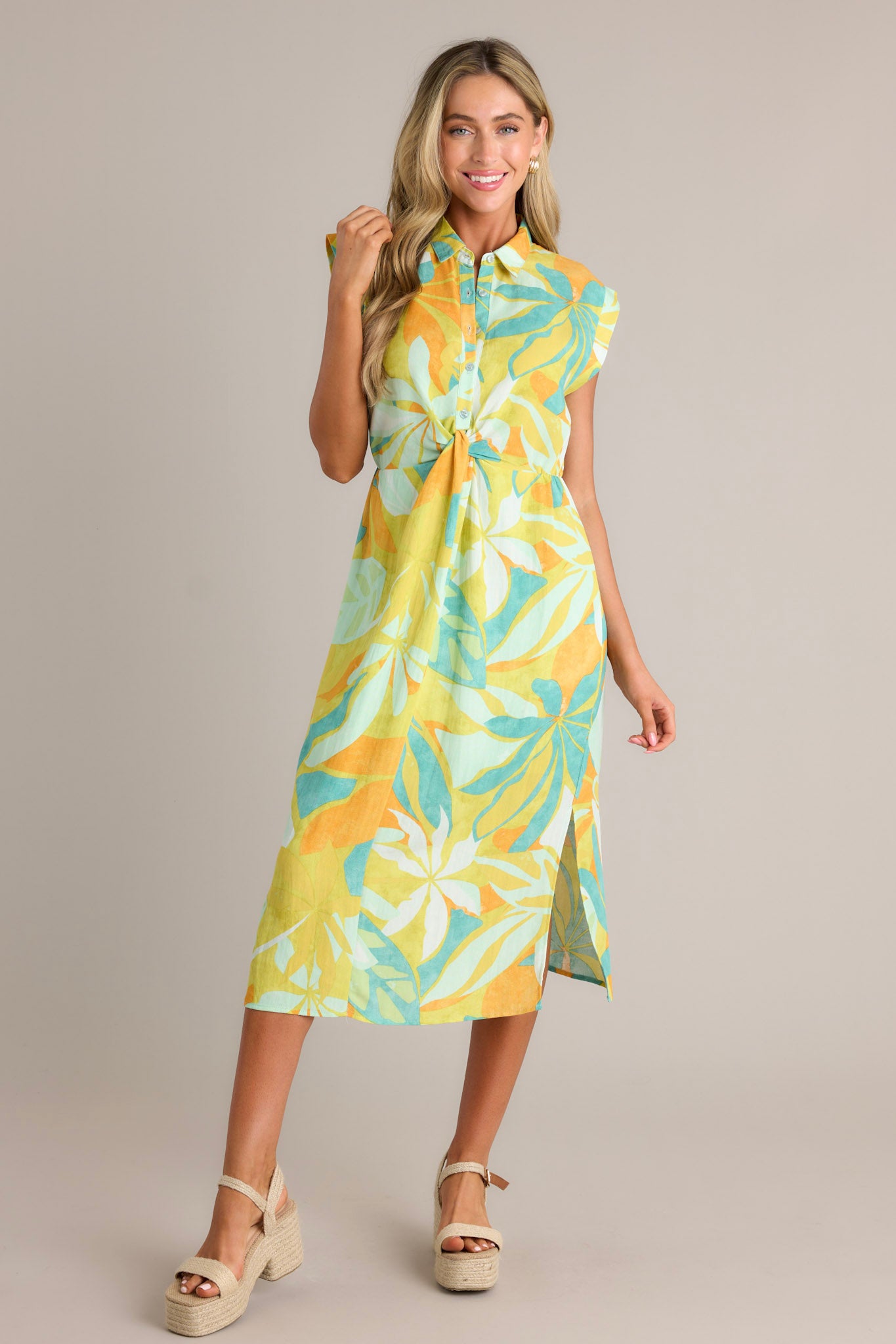 Full length view of a lime green midi dress with a collared neckline, a button front bodice, a knotted waist feature, an elastic waistline, side slits, and cuffed short sleeves