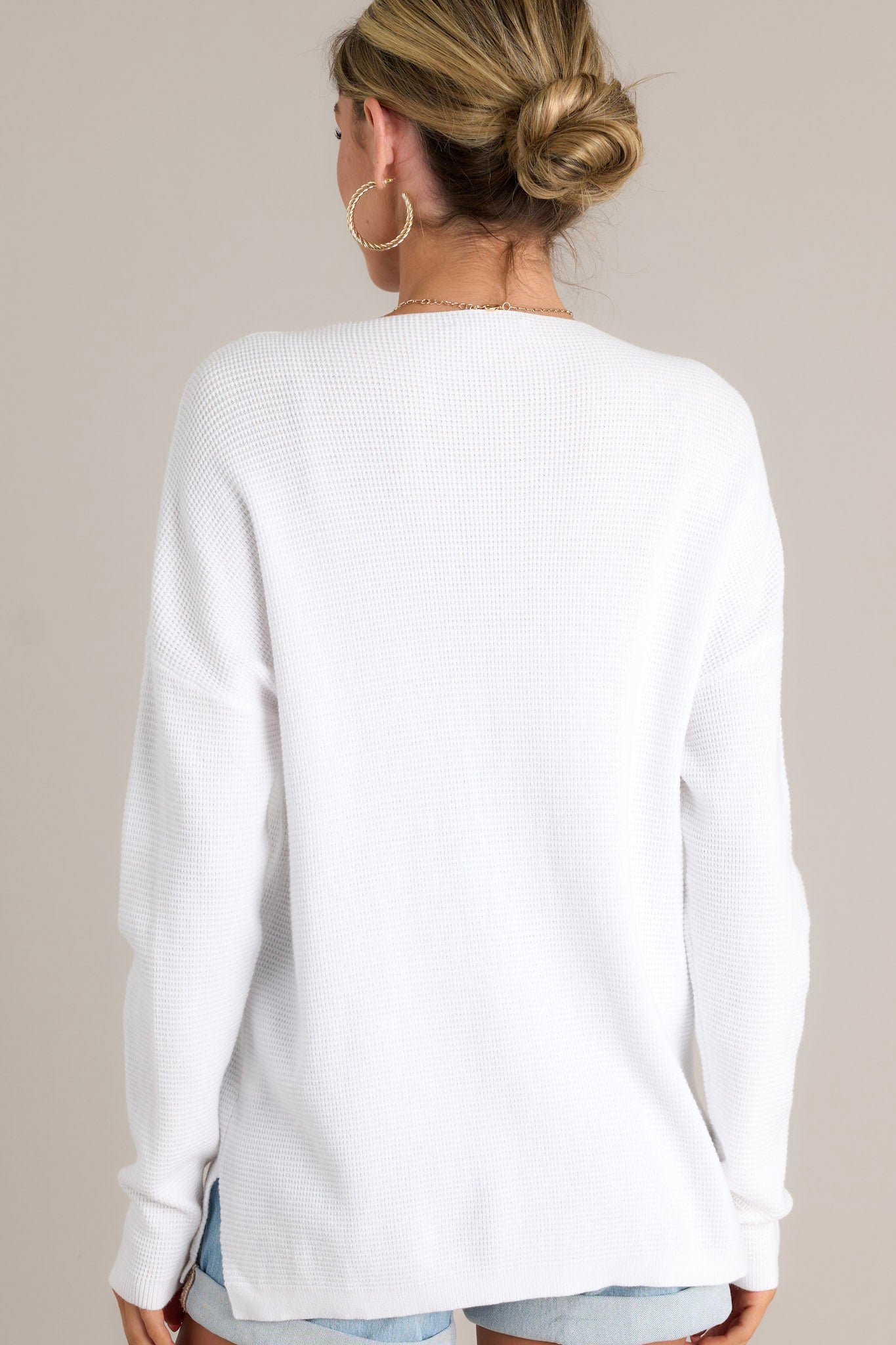 Back view of a sweater highlighting the waffle knit texture, ribbed cuffs, and overall fit.