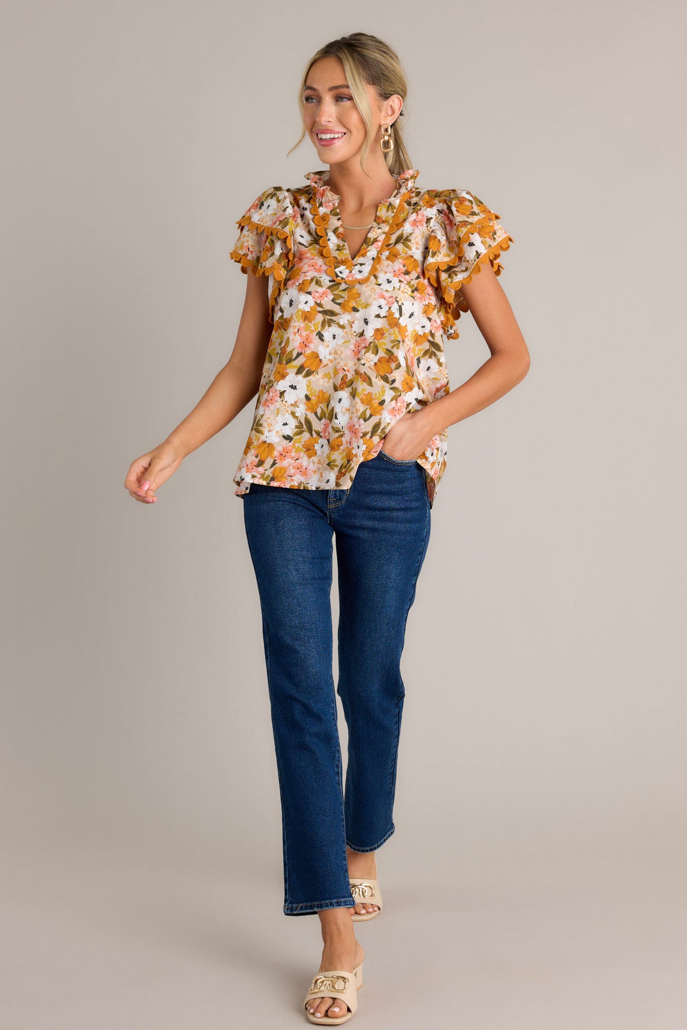 Action shot of a yellow top displaying the fit and movement, highlighting the ruffled v-neckline, scalloped detailing, lightweight material, and layered scalloped short sleeves.