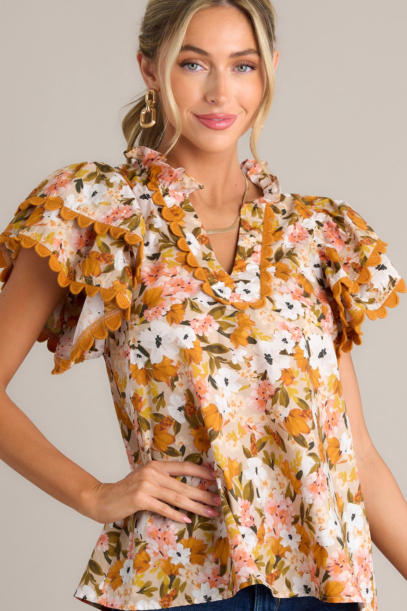 This yellow top features a ruffled v-neckline, scalloped detailing, a light weight material, and layered scalloped short sleeves.