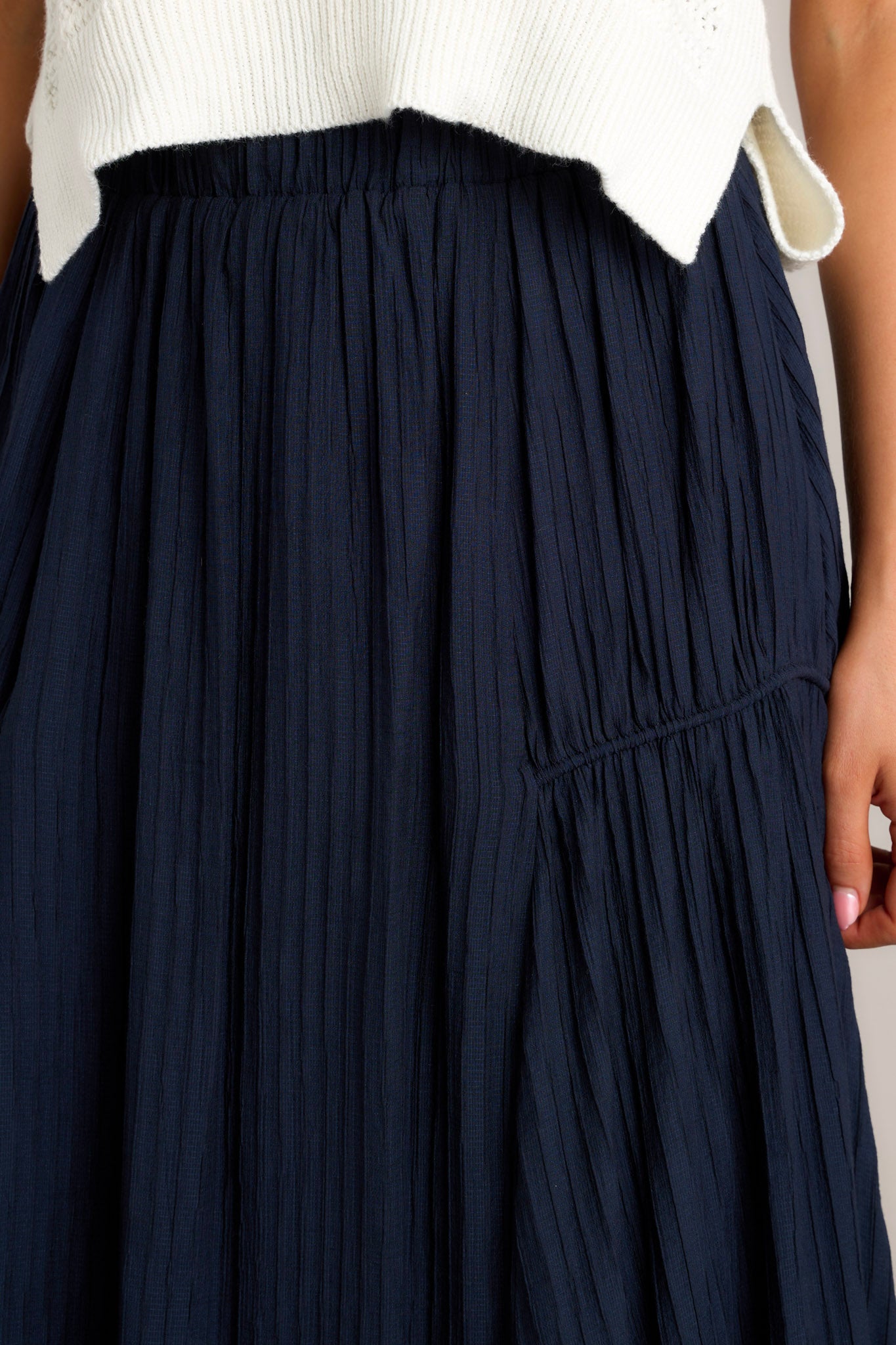 Close-up of the navy skirt showing the ribbed texture, elastic waistband, and the fabric's detail.