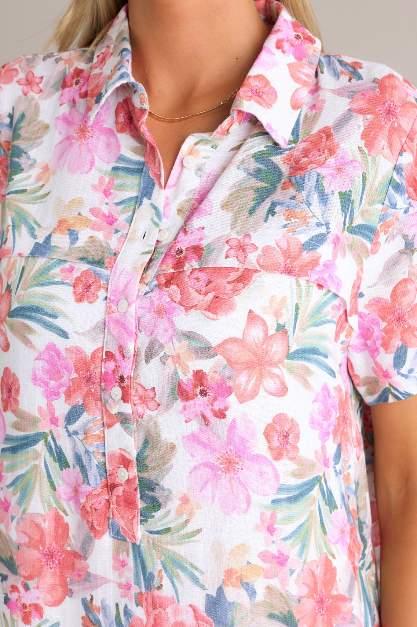 Close-up of the floral mini dress showing the collared neckline, half button front, and the floral pattern.