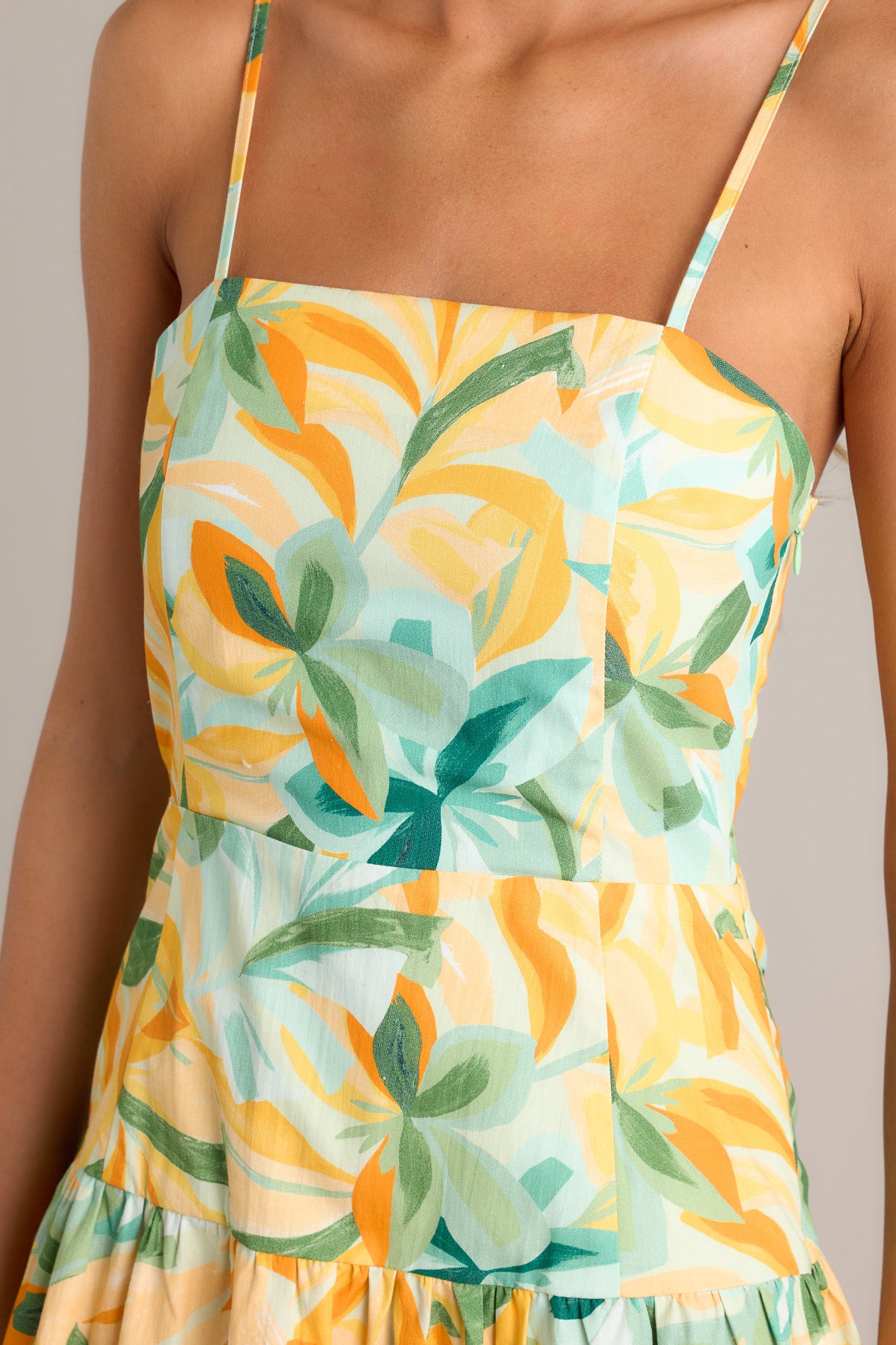 Close-up of the yellow midi dress showing the square neckline, discreet side zipper, and smocked back insert.