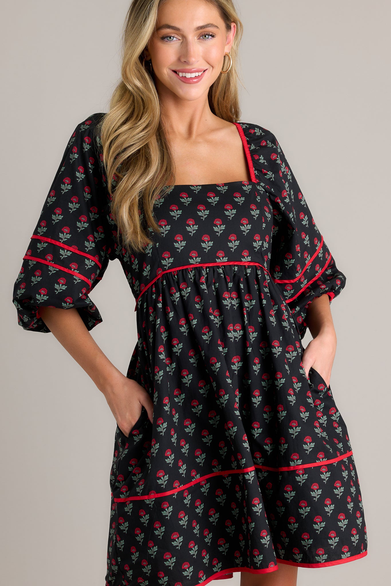 This floral puff sleeve dress features a square neckline, functional hip pockets, a tiered design, a self-tie back, a smocked back and elastic cuffed half sleeves.