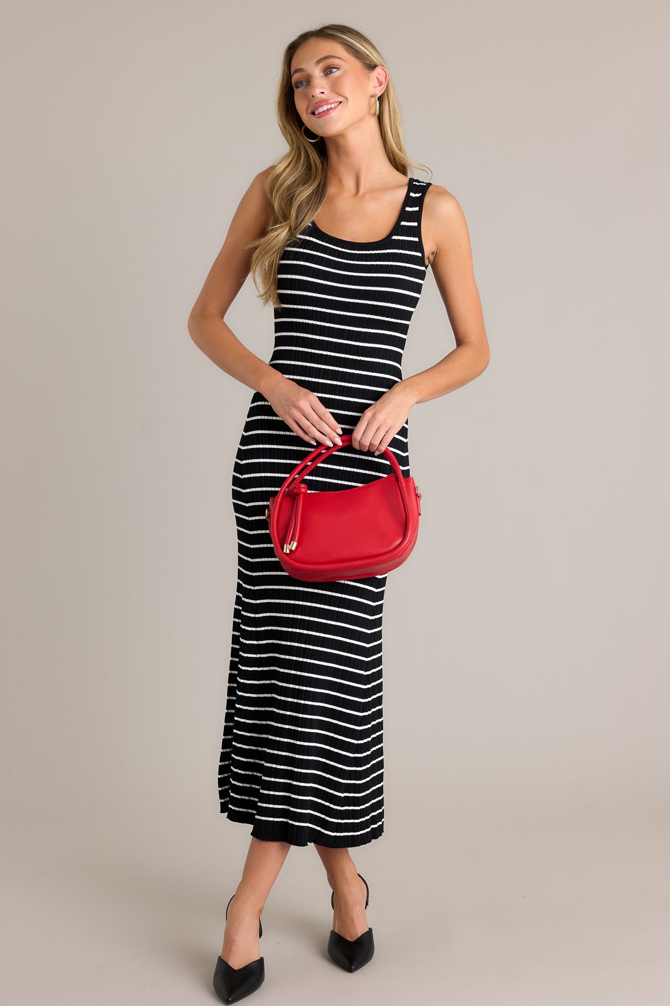 Full length view of a black stripe dress with a scoop neckline, a classic stripe design, a soft ribbed texture, and a bodycon fit