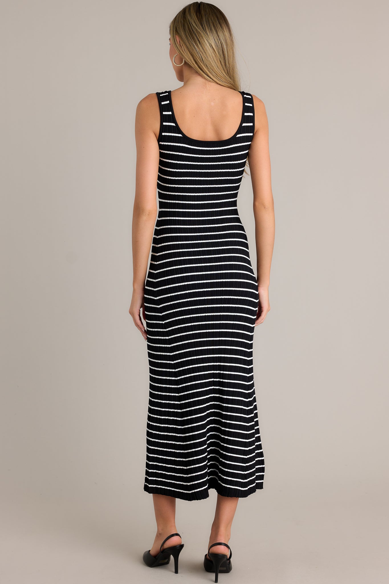 Back view of a black stripe dress highlighting the overall fit, soft ribbed texture, and classic stripe design.