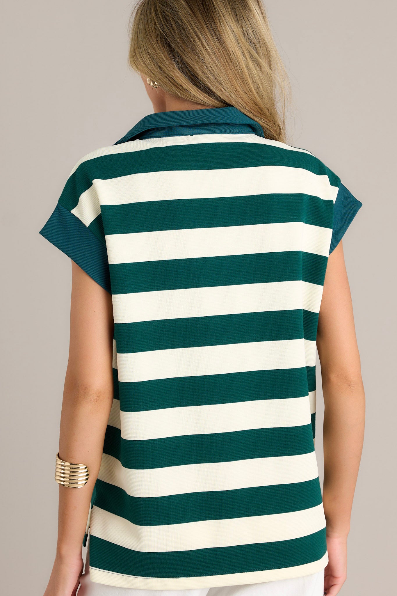 Back view of the green cap sleeve top highlighting the horizontal stripe pattern, split hem, and the relaxed fit with short cap sleeves