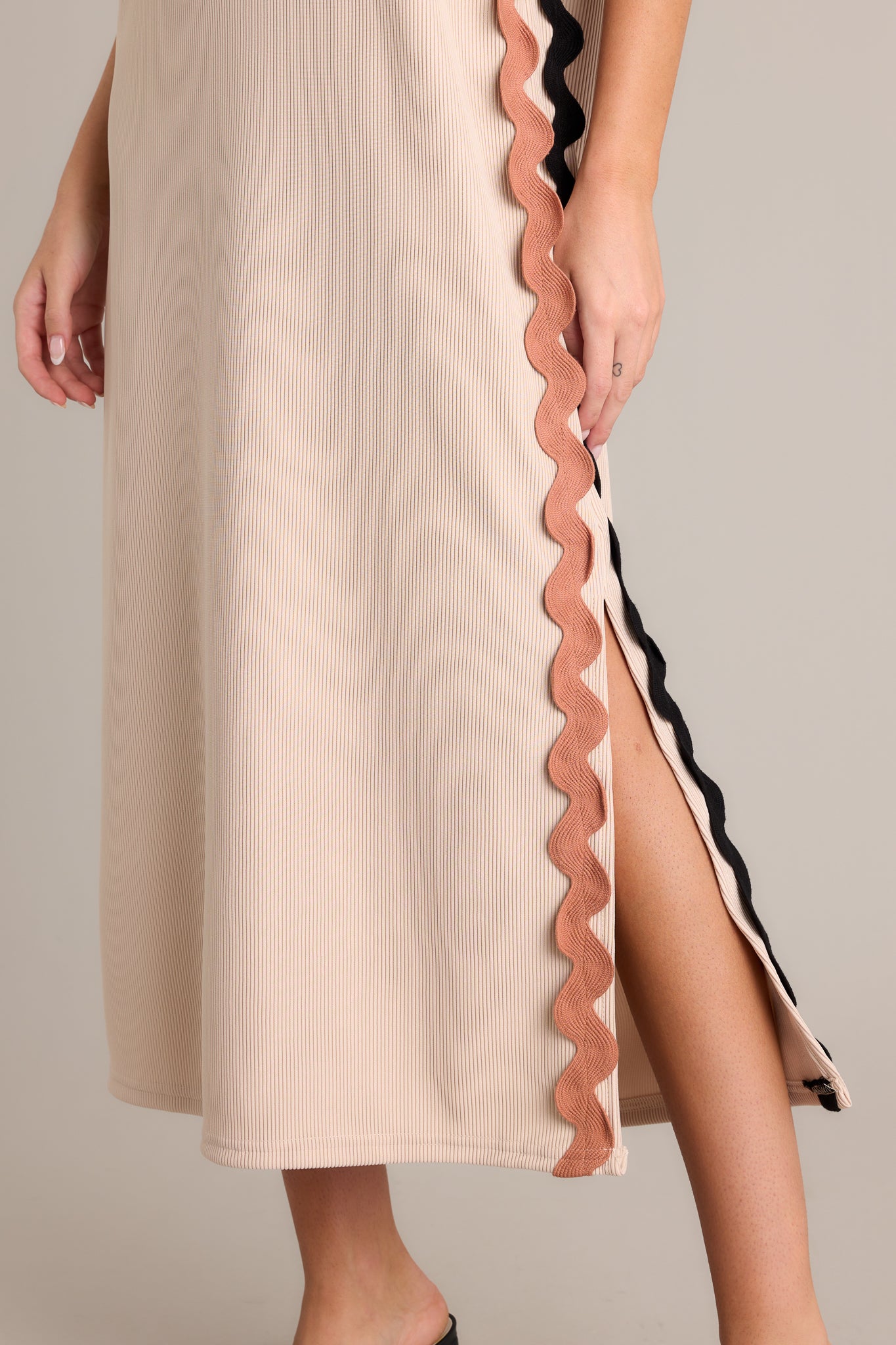 Close-up of the taupe midi dress showing the crew neckline, ribbed material, and two-toned ricrac side detailing.