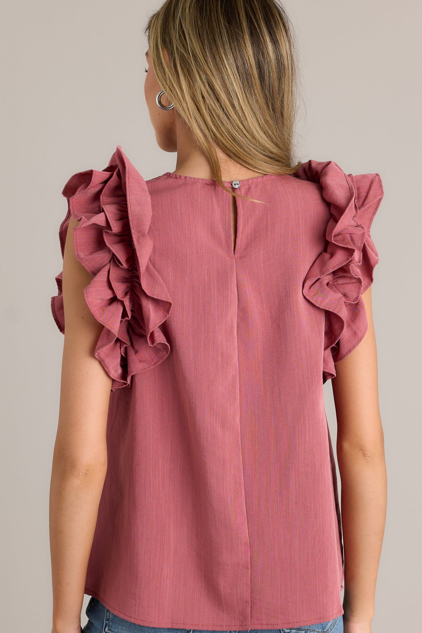 Back view of a rose top highlighting the keyhole with a button closure at the back of the neck.