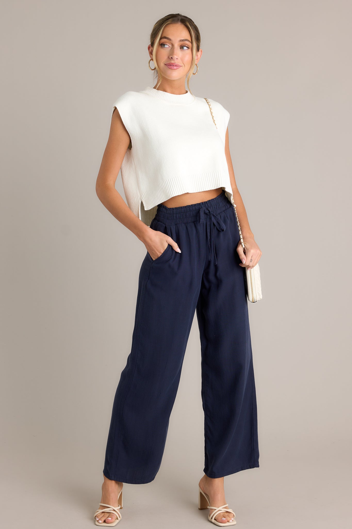 These navy pants feature a high waisted design, an elastic waistband with a self-tie drawstring, functional front & back pockets, and a wide leg.