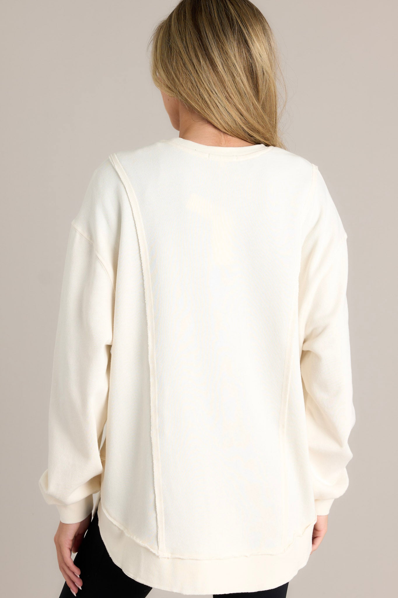 A view of the back of the sea salt sweatshirt, showcasing the clean lines and the curved hemline continuing from the front.