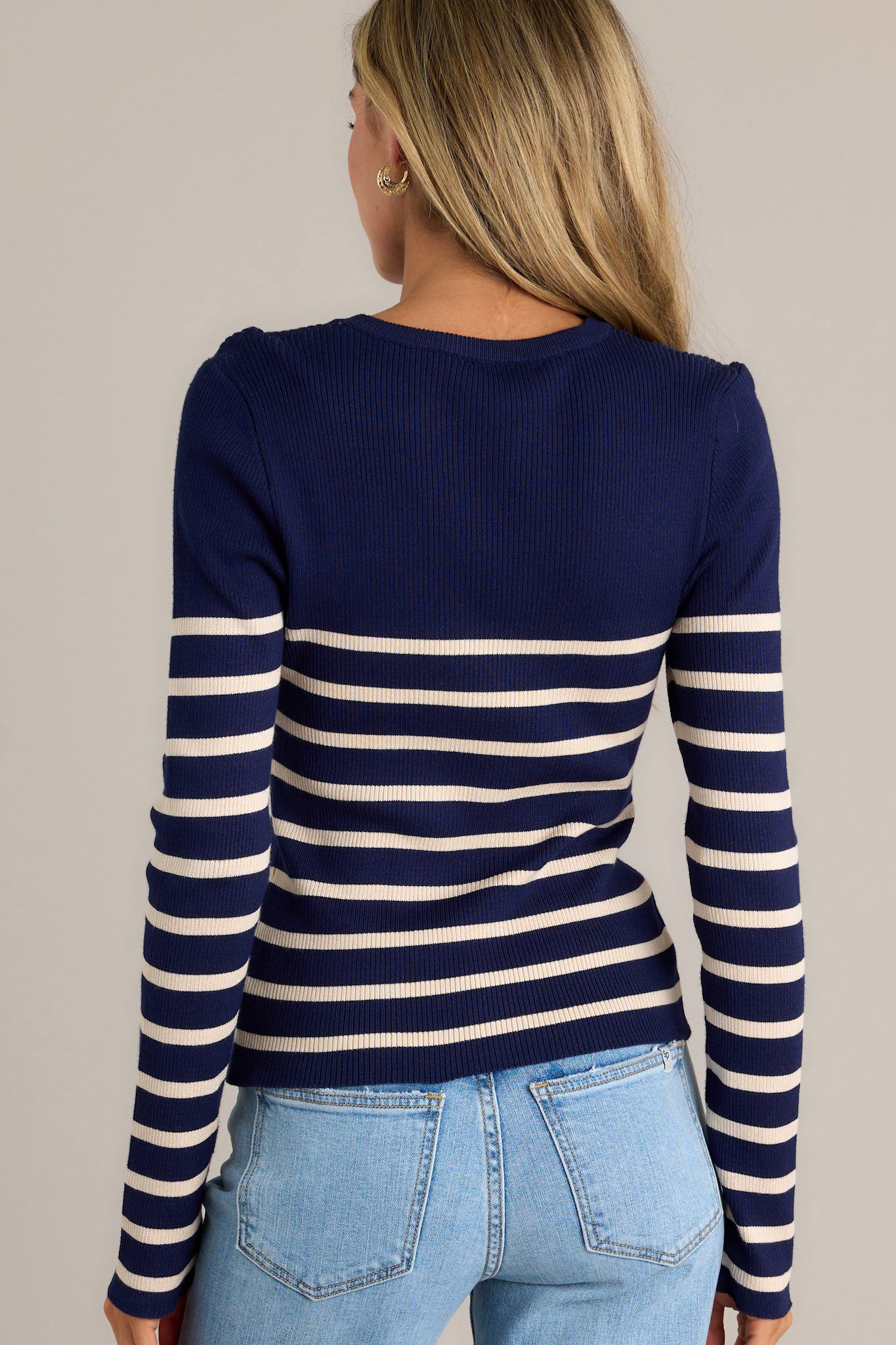 Back view of a beige stripe navy top highlighting the overall fit, striped pattern, and long sleeves.