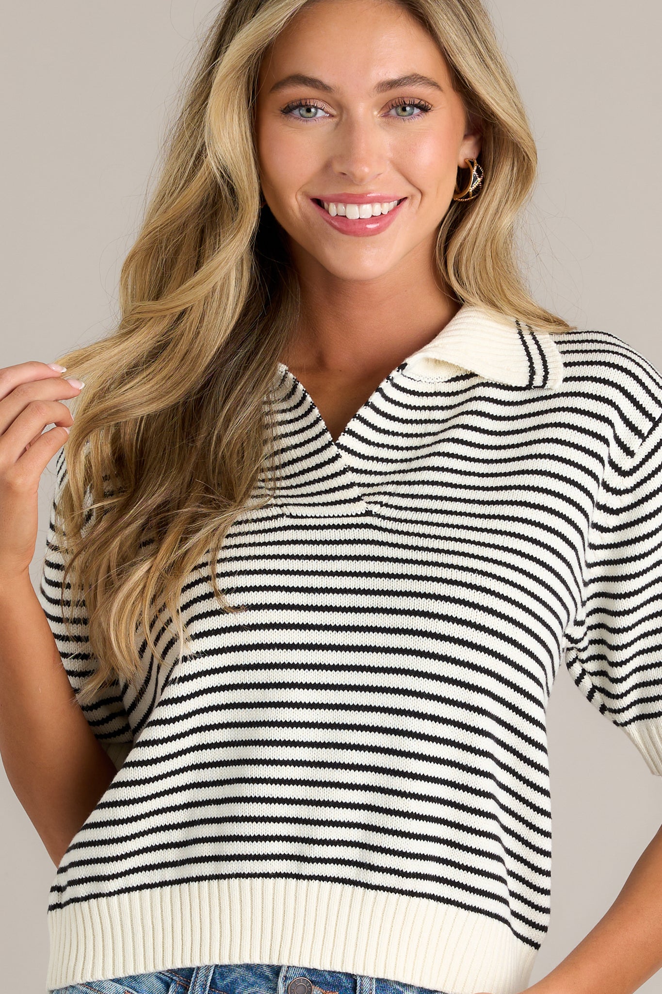 A close-up shot of the upper half, highlighting the collared v-neckline and the details of the horizontal stripe design.