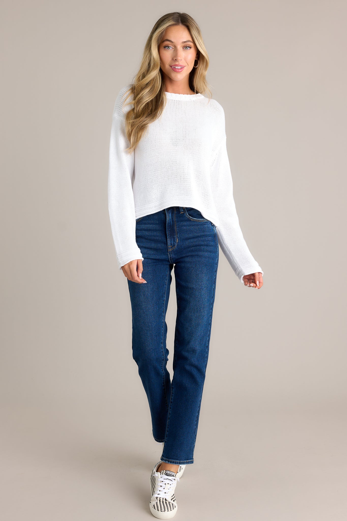 Front view of a sweater featuring a crew neckline, a cropped length, contrast detailing at the hem, and knit detailing around the neckline.