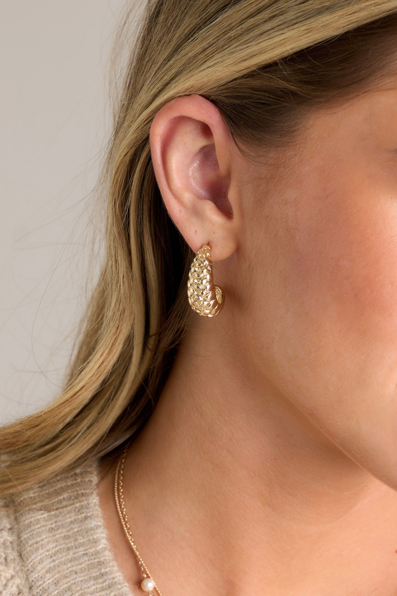 These gold earrings feature a textured gold hardware,&nbsp; a thick incomplete hoop, and secure post hole backings.