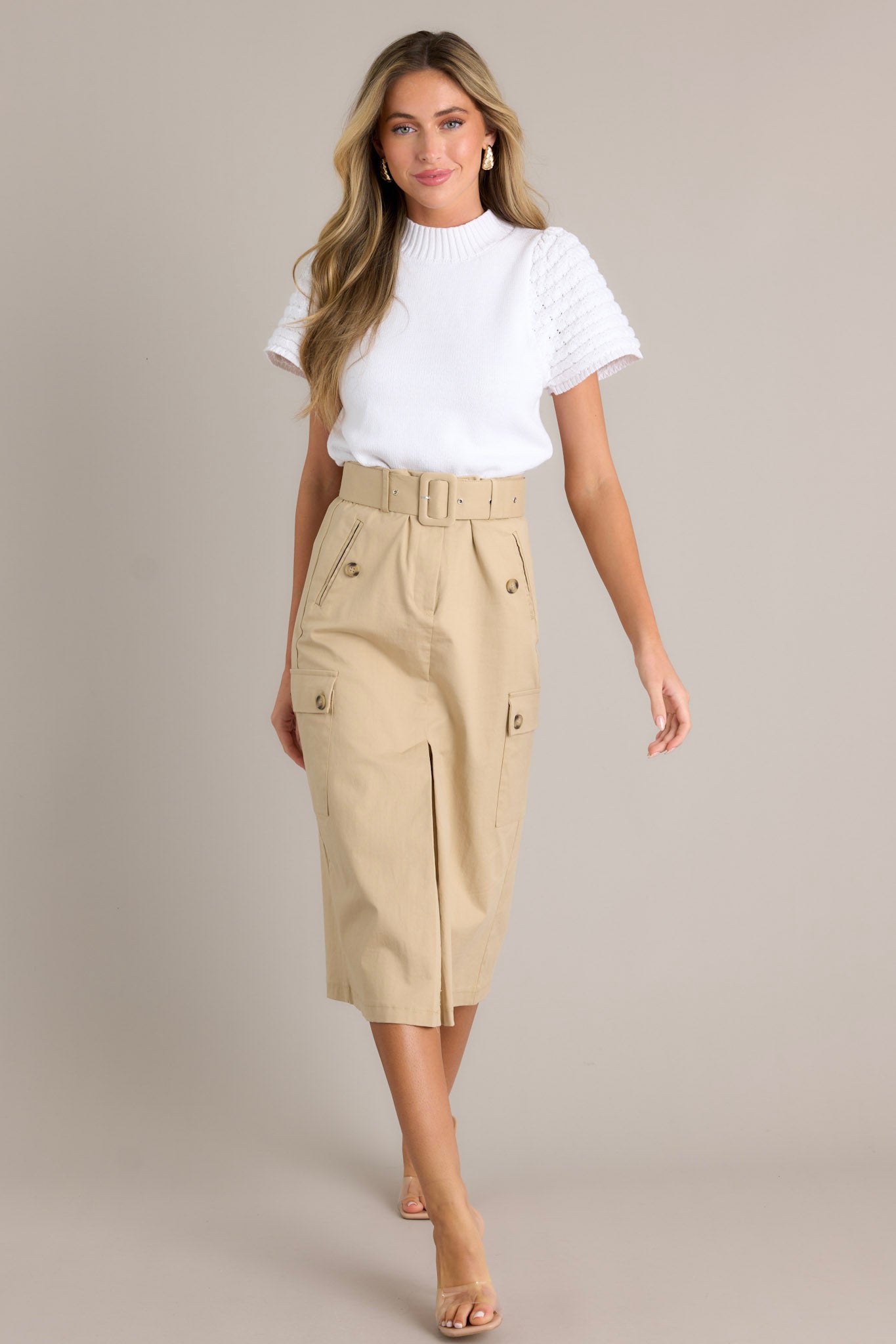 This skirt features a high waisted design, a zipper & button closure, belt loops, a functional belt, 4 functional pockets, and a faux slit in the front.