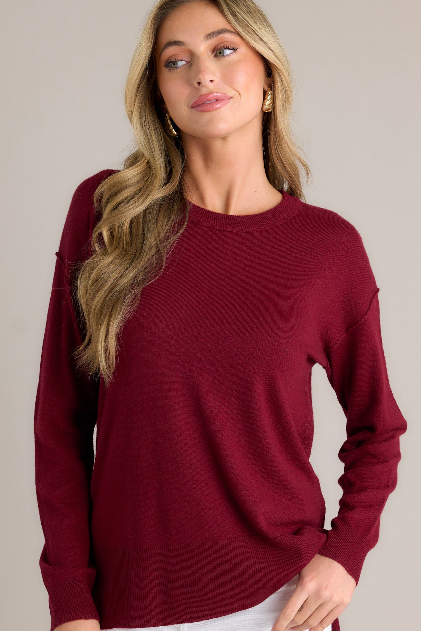 Front view of this sweater that features a round neckline, long sleeves with ribbed cuffs, a bottom hemline that is slightly longer in the back and has slits up both sides, and a super soft feel throughout.