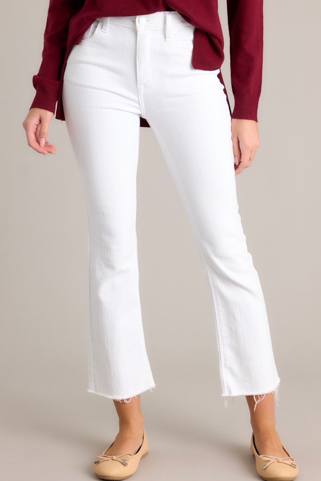 These white jeans feature a high waisted design, a classic button &amp; zipper closure, belt loops, functional front & back pockets, and a raw, cropped hemline.