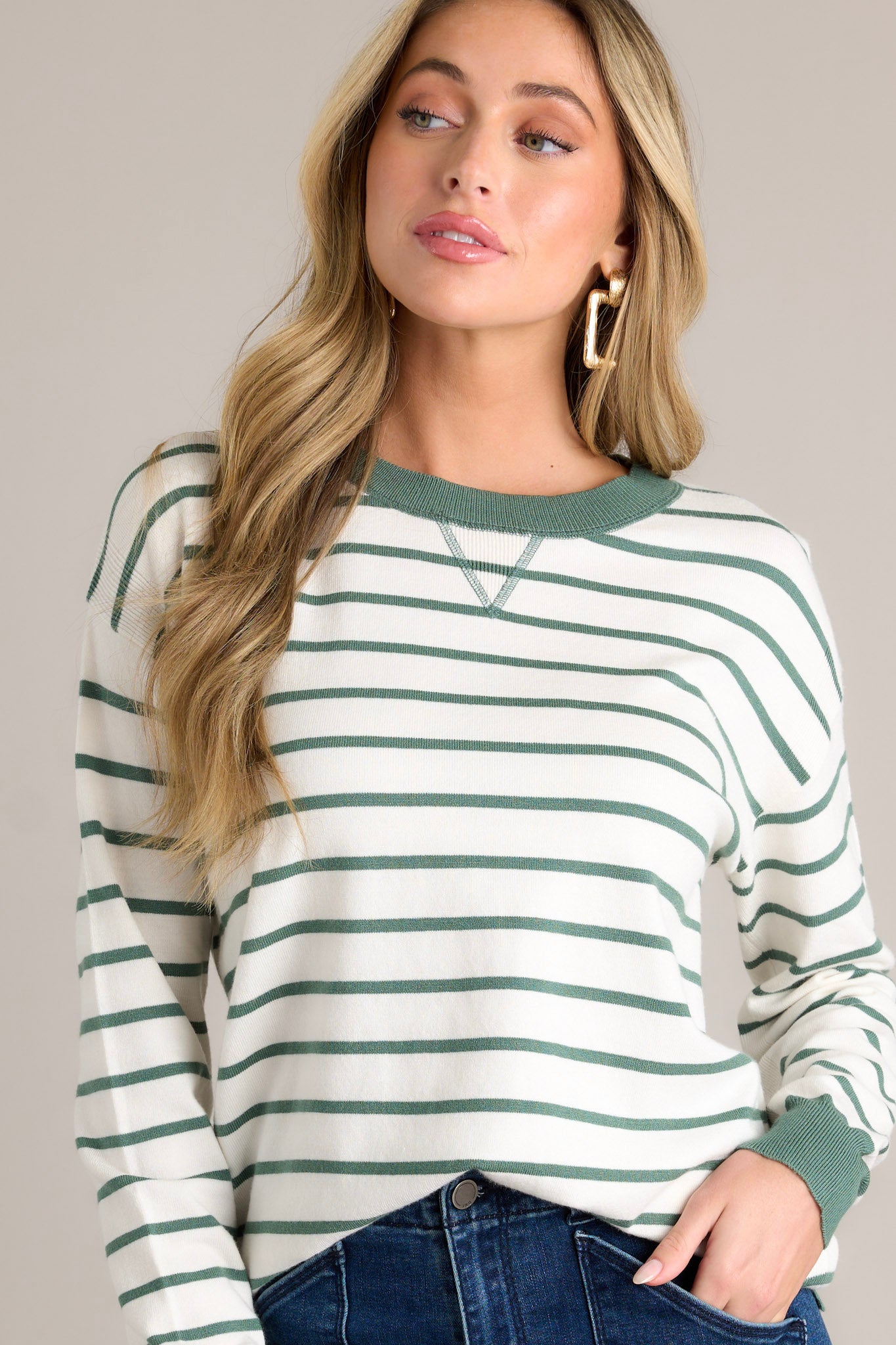 This strip long sleeve features a rounded neckline, a green horizontal stripe design, green trim, long cuffed sleeves and a thick hem with side slits.