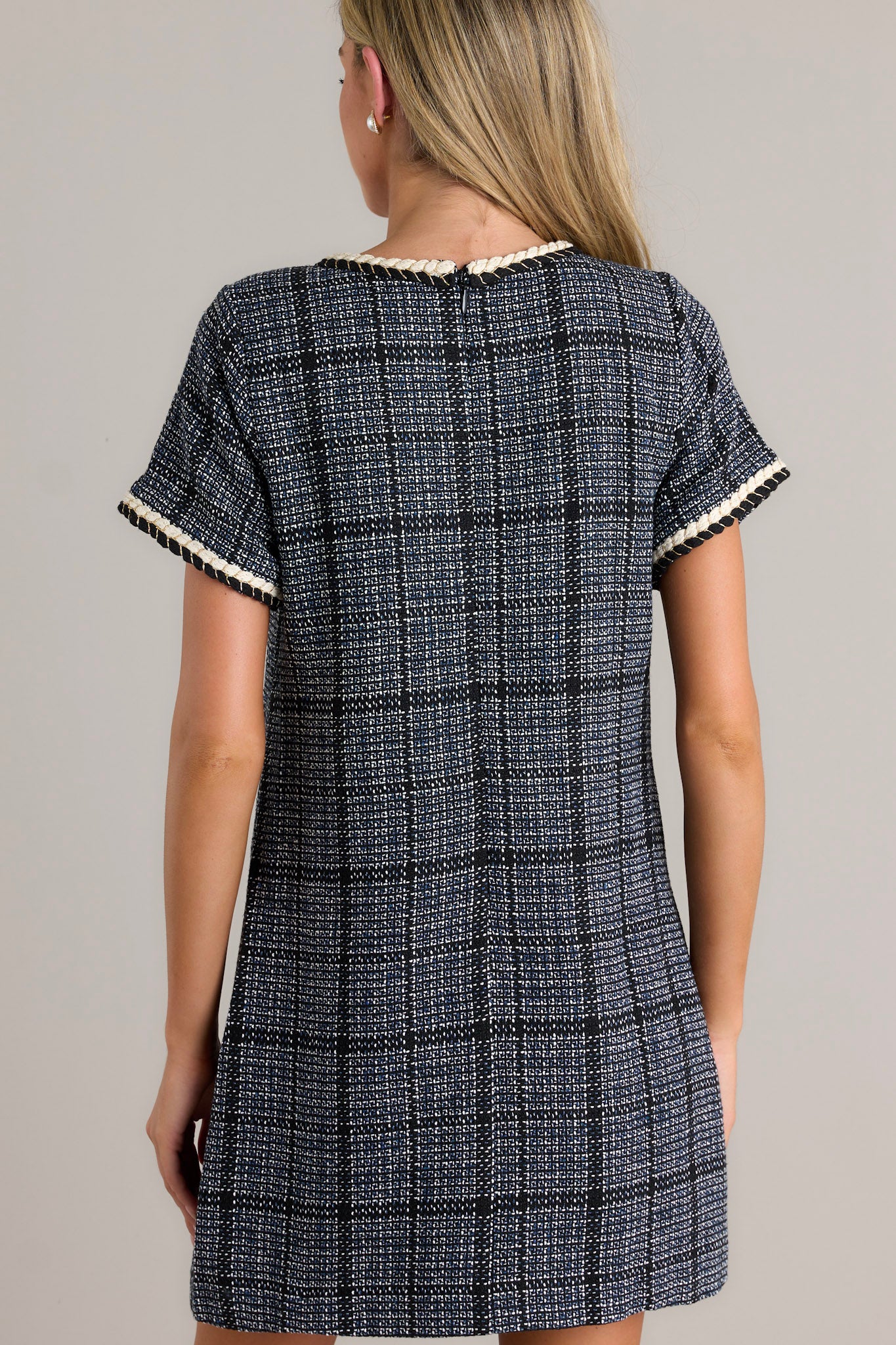 Back view of a tweed dress highlighting the overall fit and short sleeves.