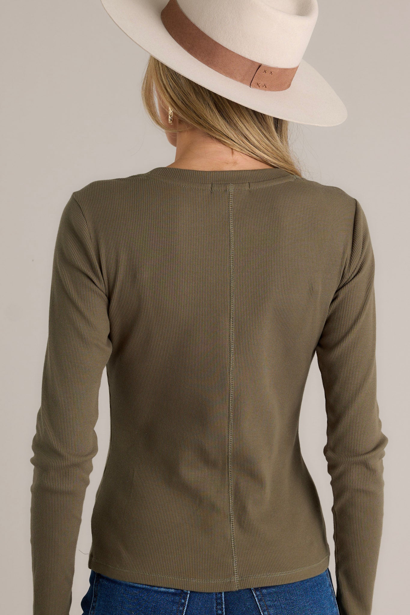 Back view of a green top highlighting the ribbed detailing and long sleeves.