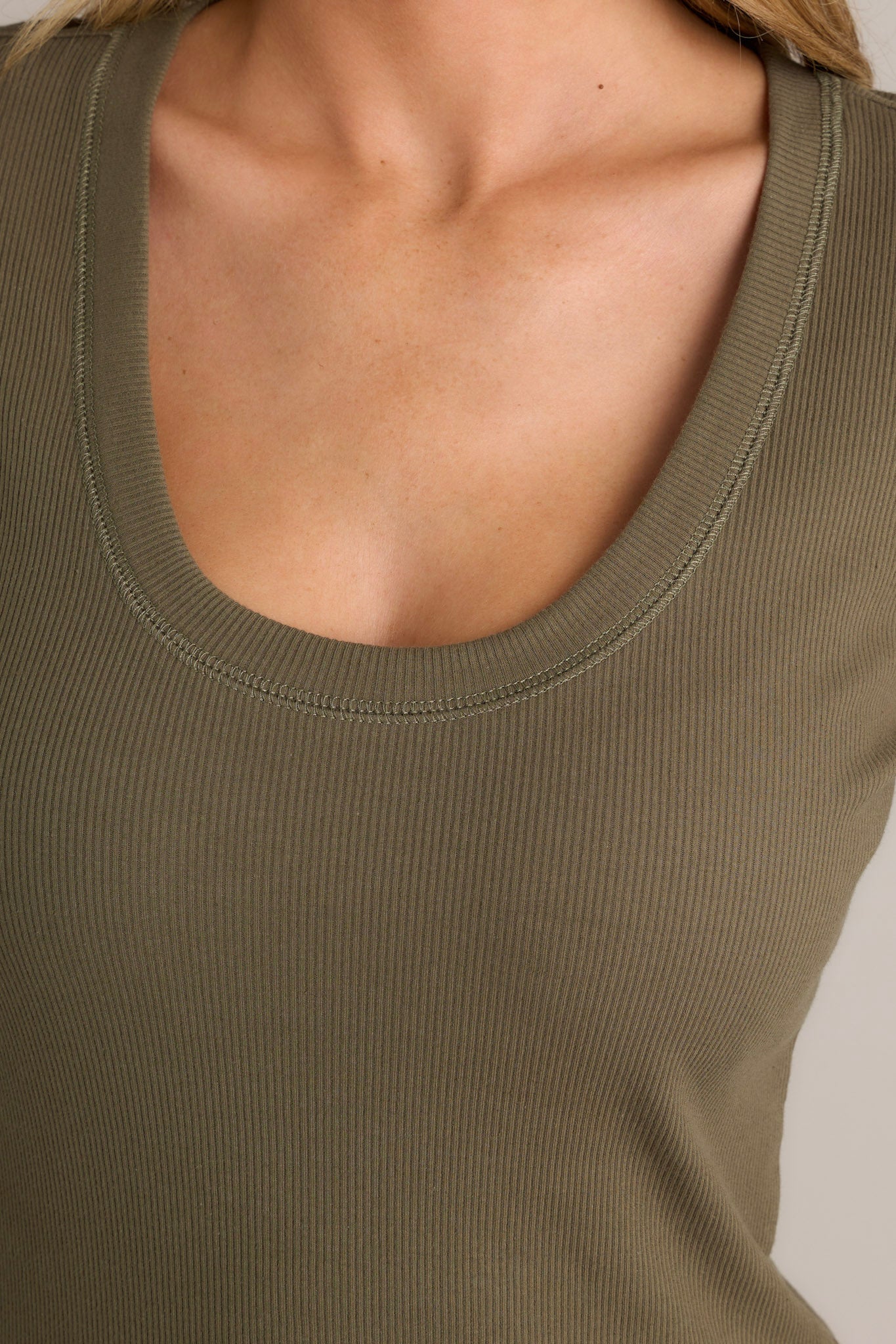 Close-up of the green top showing the scoop neckline and ribbed detailing.