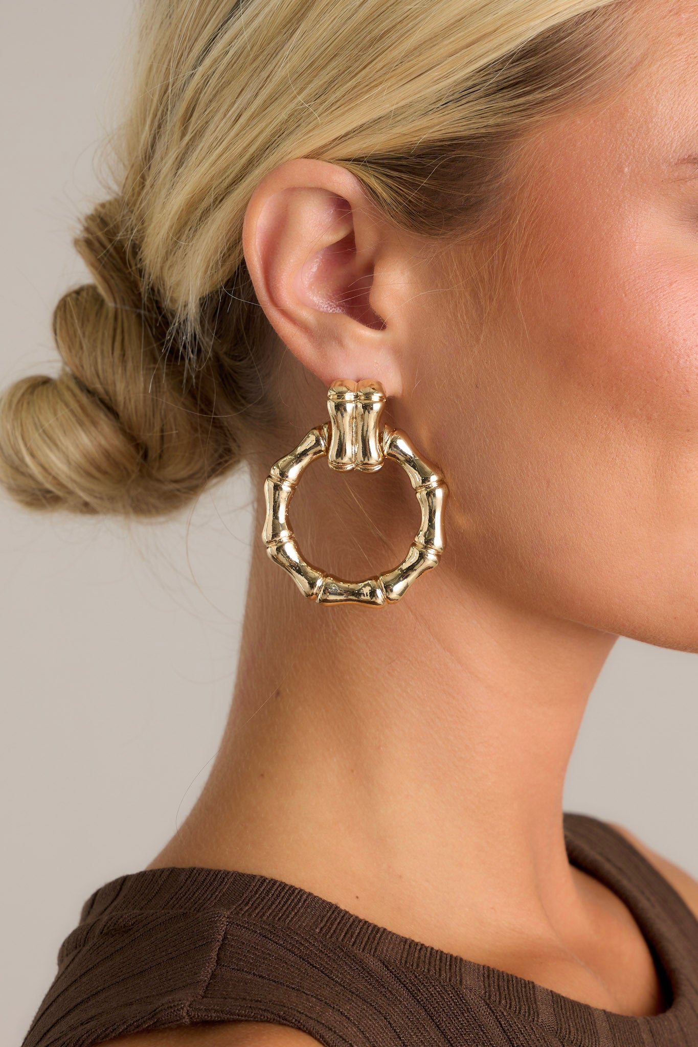 These gold earrings feature textured gold hardware,&nbsp;a textured stud with a connected textured hoop, and secure post backings.