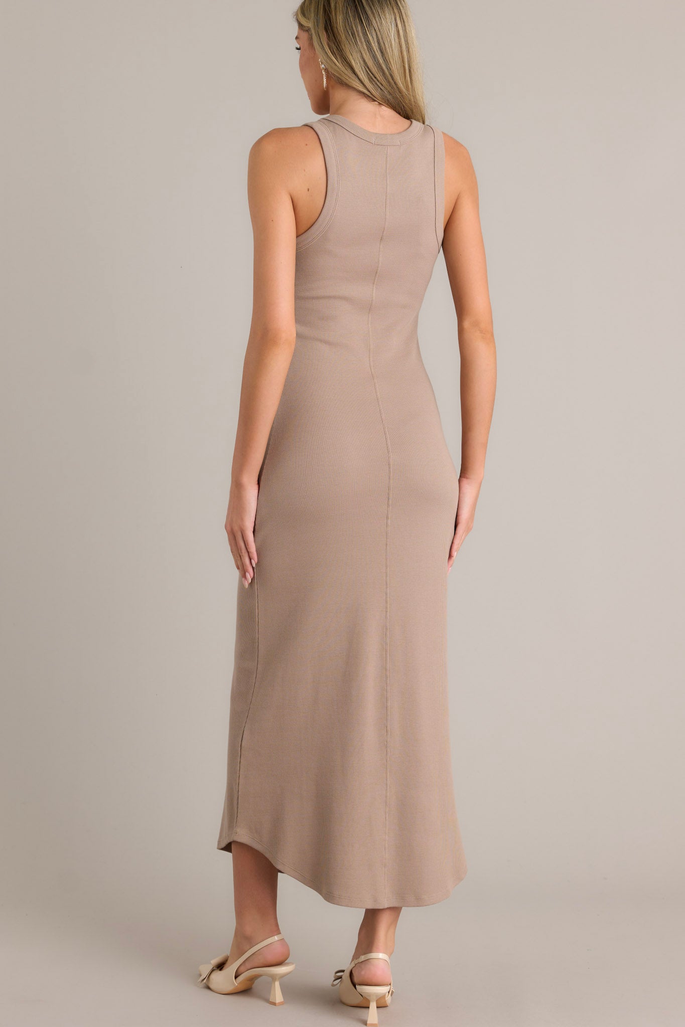 Back view of this tan bodycon midi dress with ribbed fabric and a scoop hem.