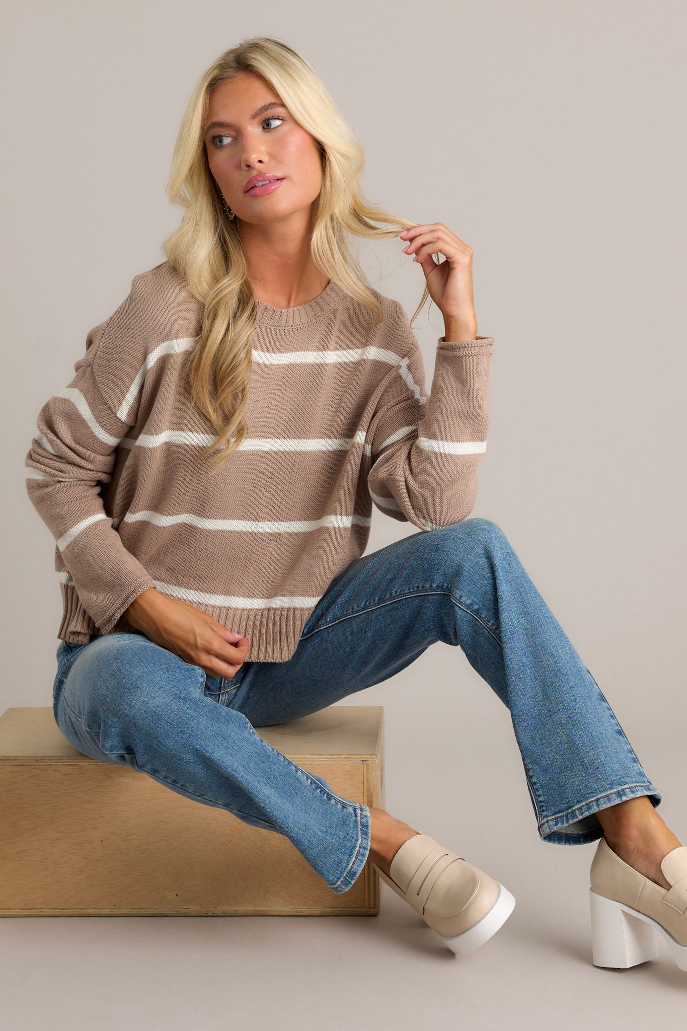 The latte tan stripe sweater with a round neckline, ribbed hems, and long dolman sleeves.