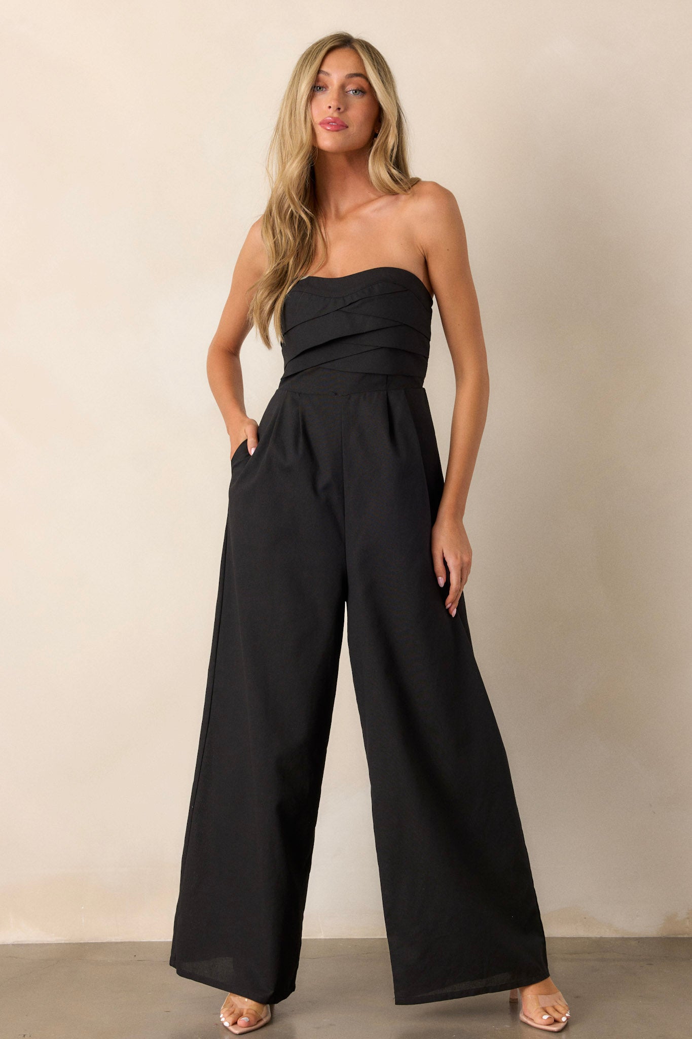 Front view of a jumpsuit featuring a smocked back, wide leg bottoms, and a stretchy band on the bust for support.