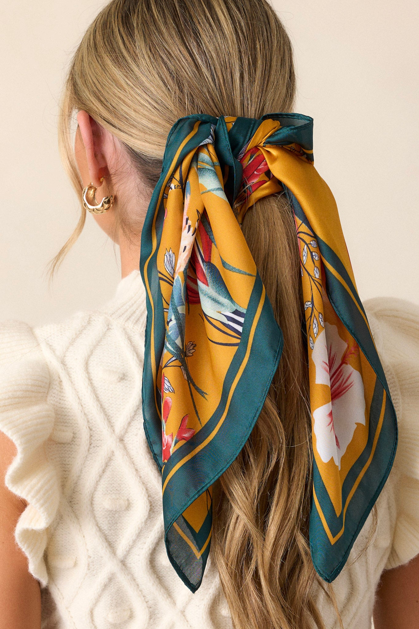 This green floral scarf features an green border and a flower field print.