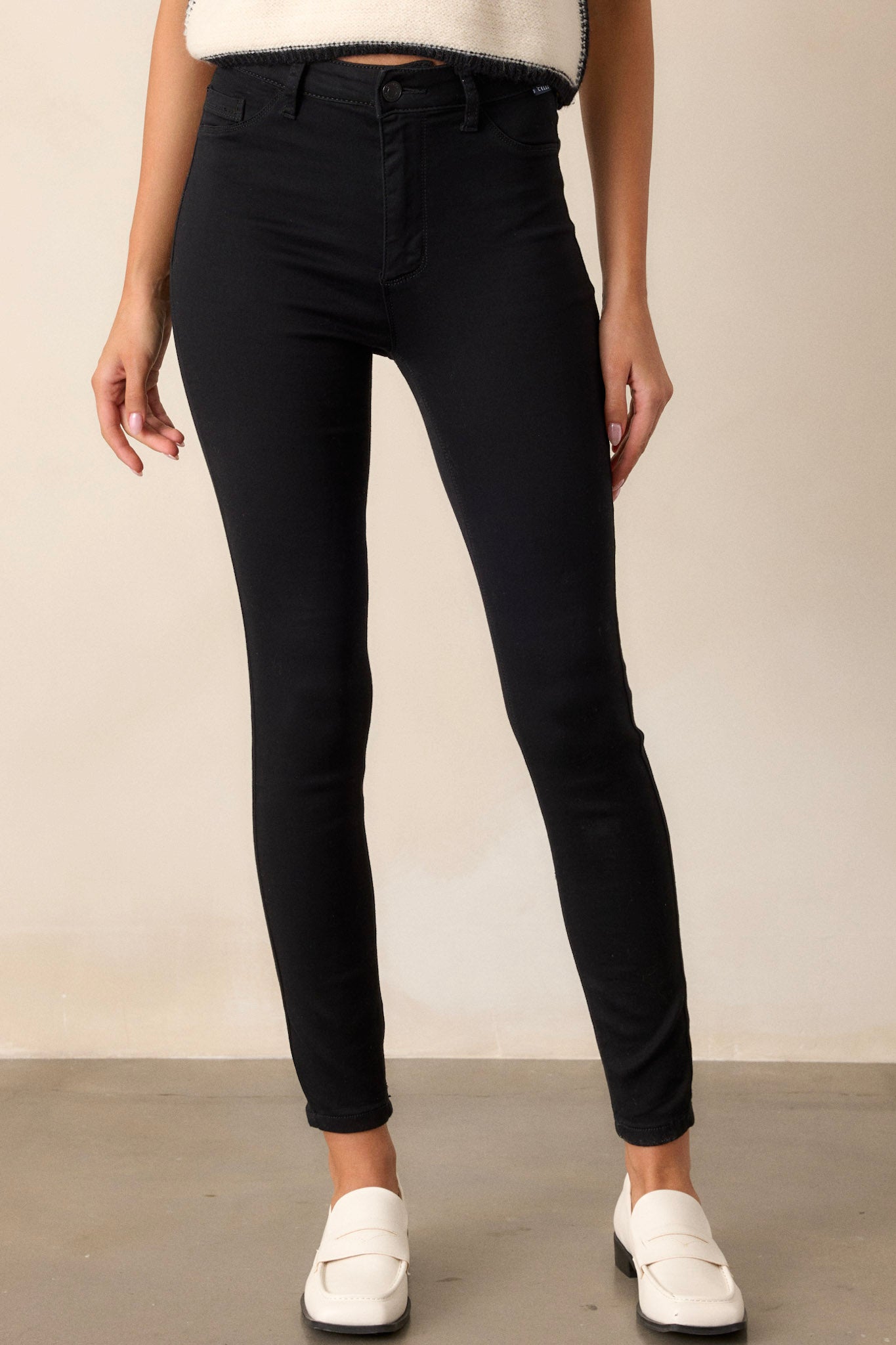 These black skinny jeans feature a zipper and button closure, functional belt loops, and faux front pockets.