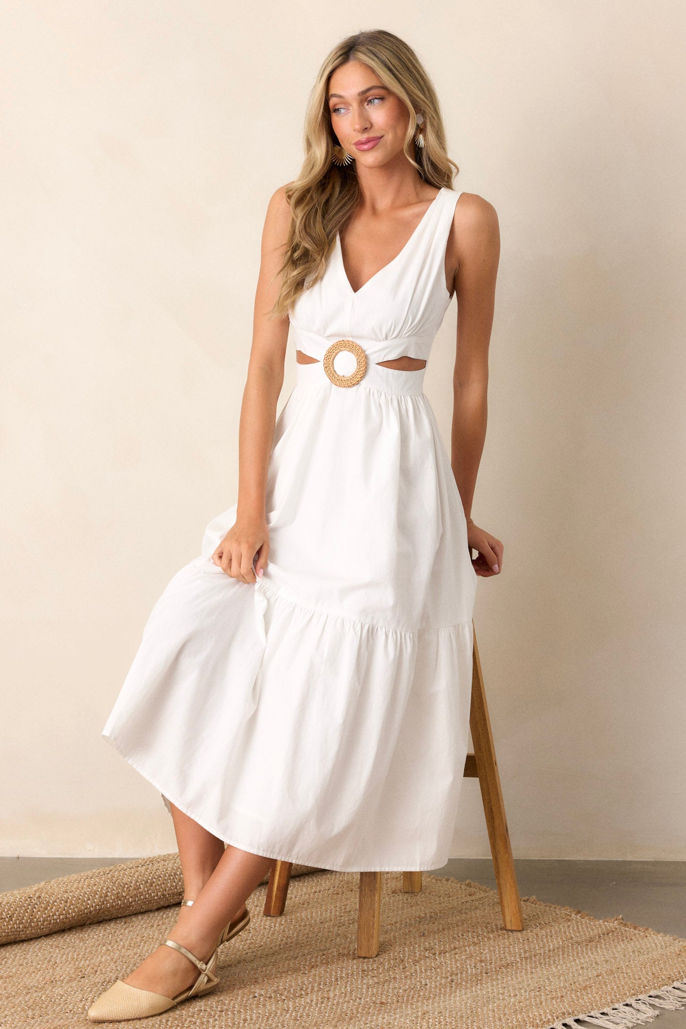 Full length view of a dress with a v-neckline, bamboo circle detail, waist cutouts on both sides, a self-tie at the back of the straps, and a smocked insert in the back of the bust