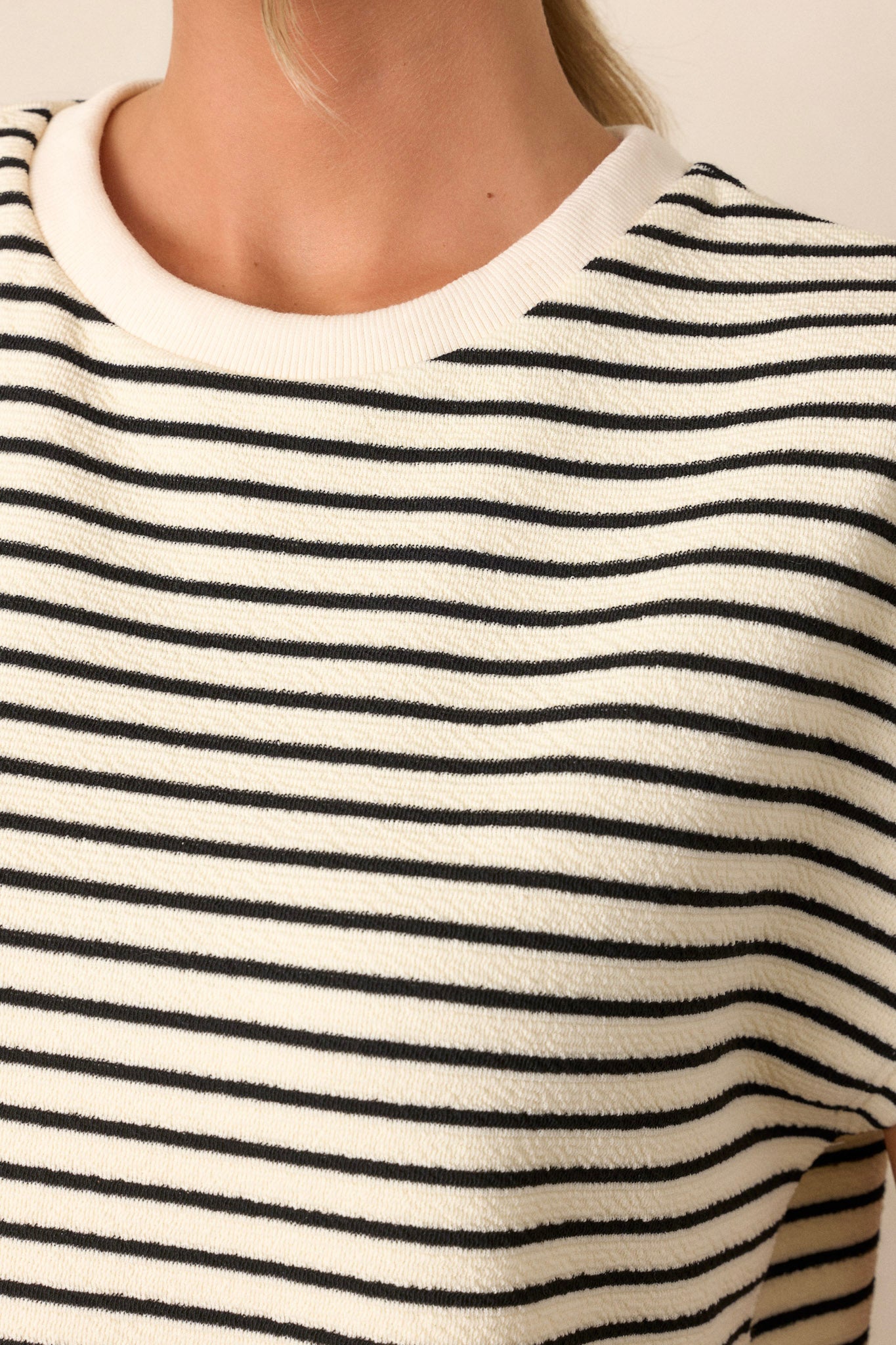 Close-up of the ivory top focusing on the ribbed neckline and the texture of the cap sleeves.