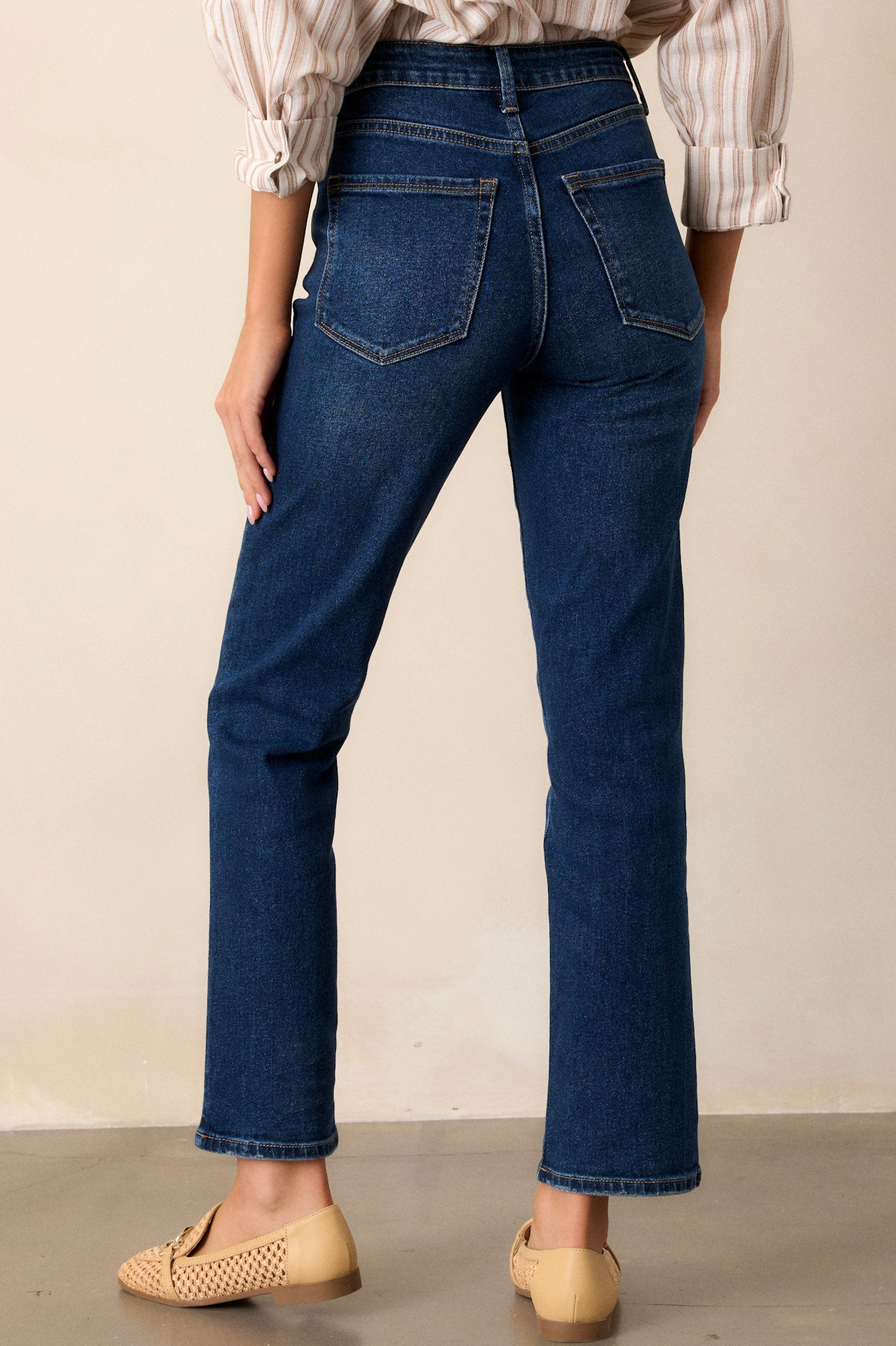 Back view of the dark wash jeans highlighting the high waist, straight leg fit, and the functional back pockets.