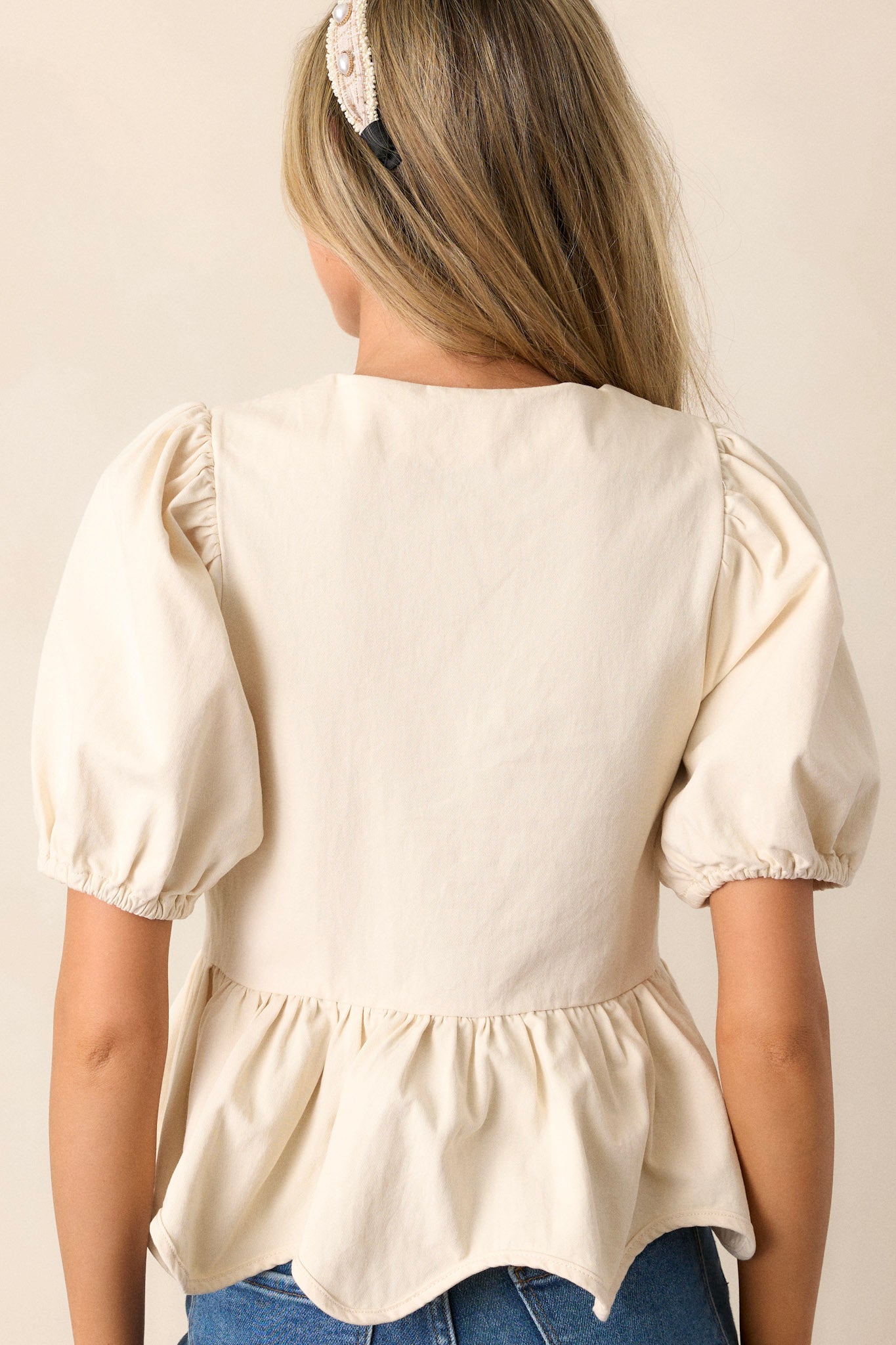 Back view of the ivory top highlighting the puff sleeves and the smooth, seamless back design without visible closures.