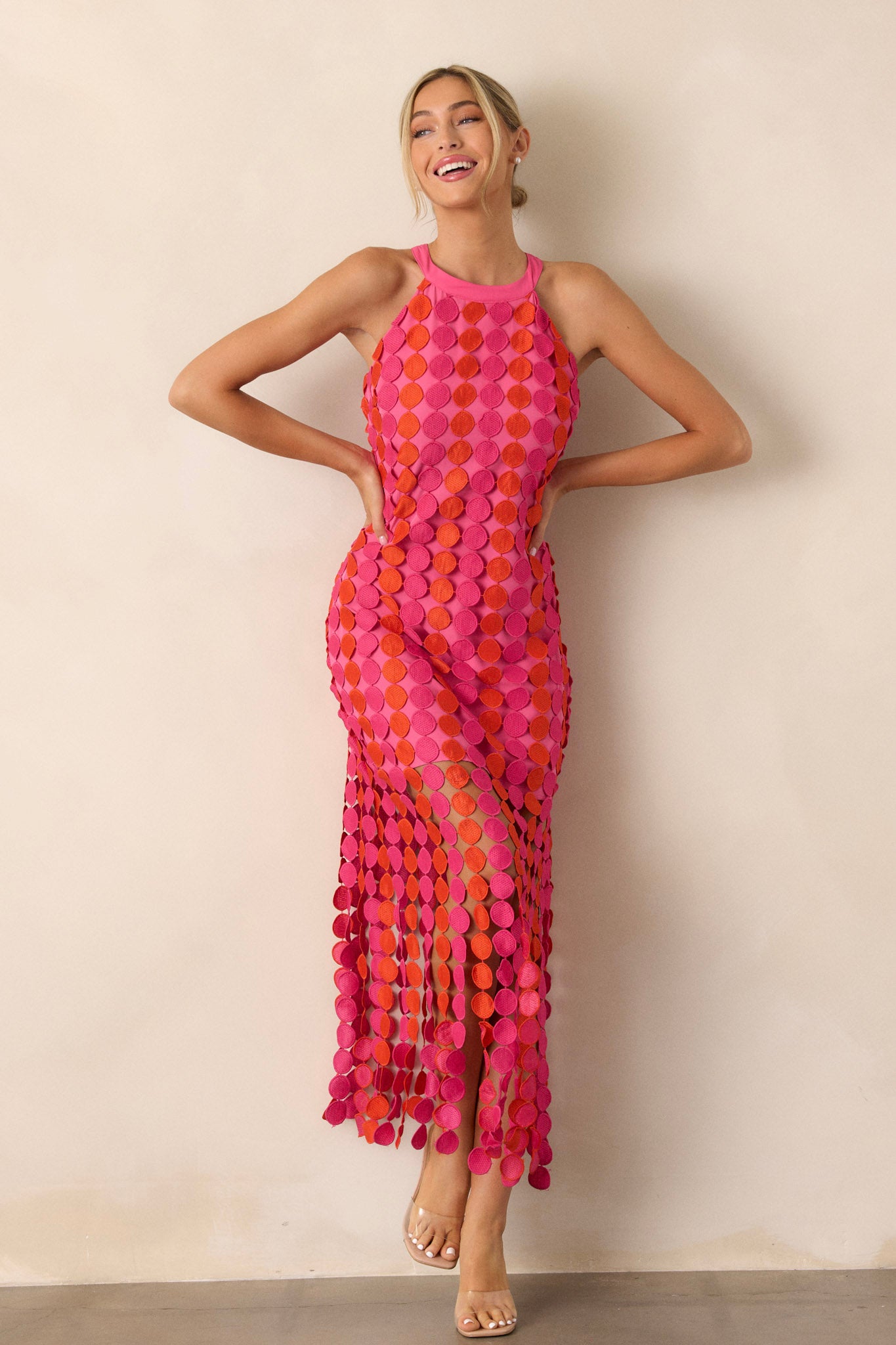 Front view of a dress featuring vibrant pink and orange fun fringe, a tie halter neckline, and a functional zipper at the back.