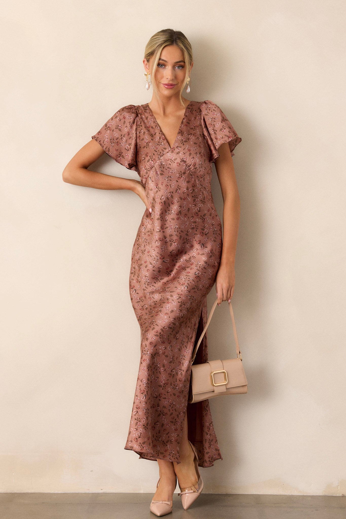 This dusty rose dress features a plunge v-neck, flutter sleeves, a functional back zipper and a high leg slit.